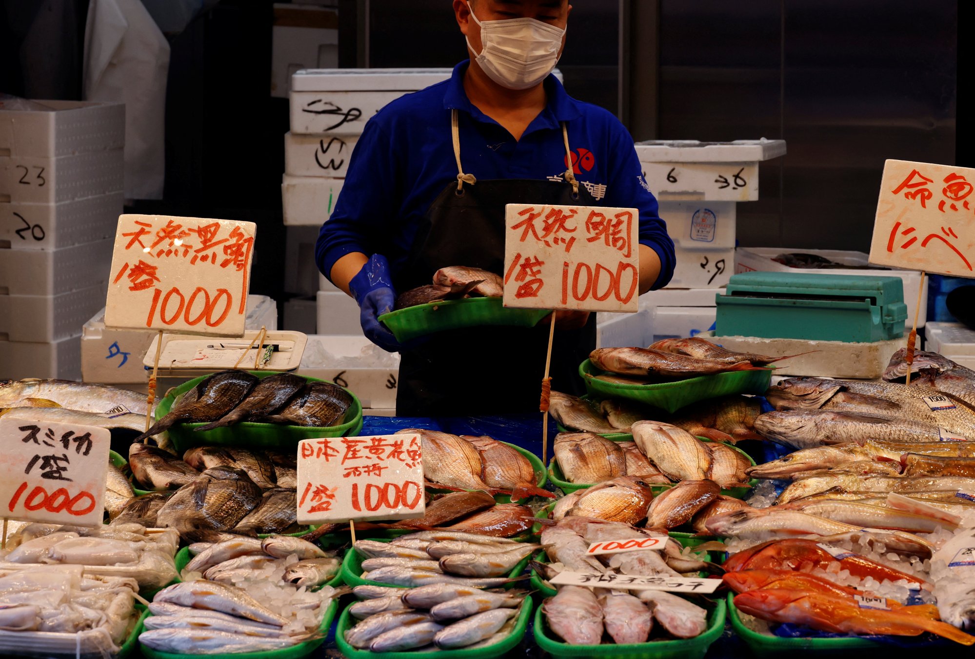 A vendor sells fish at a shop at a shopping district in Tokyo. Photo: Reuters