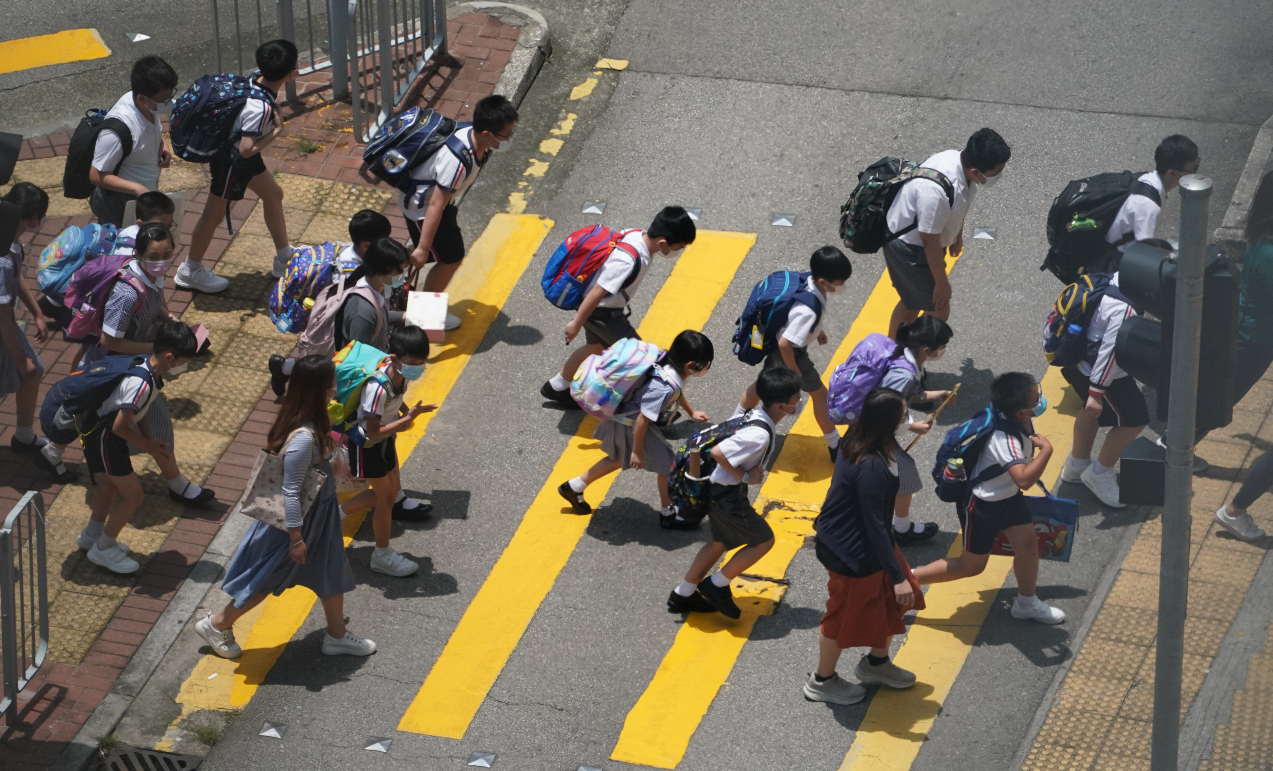 A teacher guides primary school pupils across the road in Tsuen Wan. Photo: Felix Wong