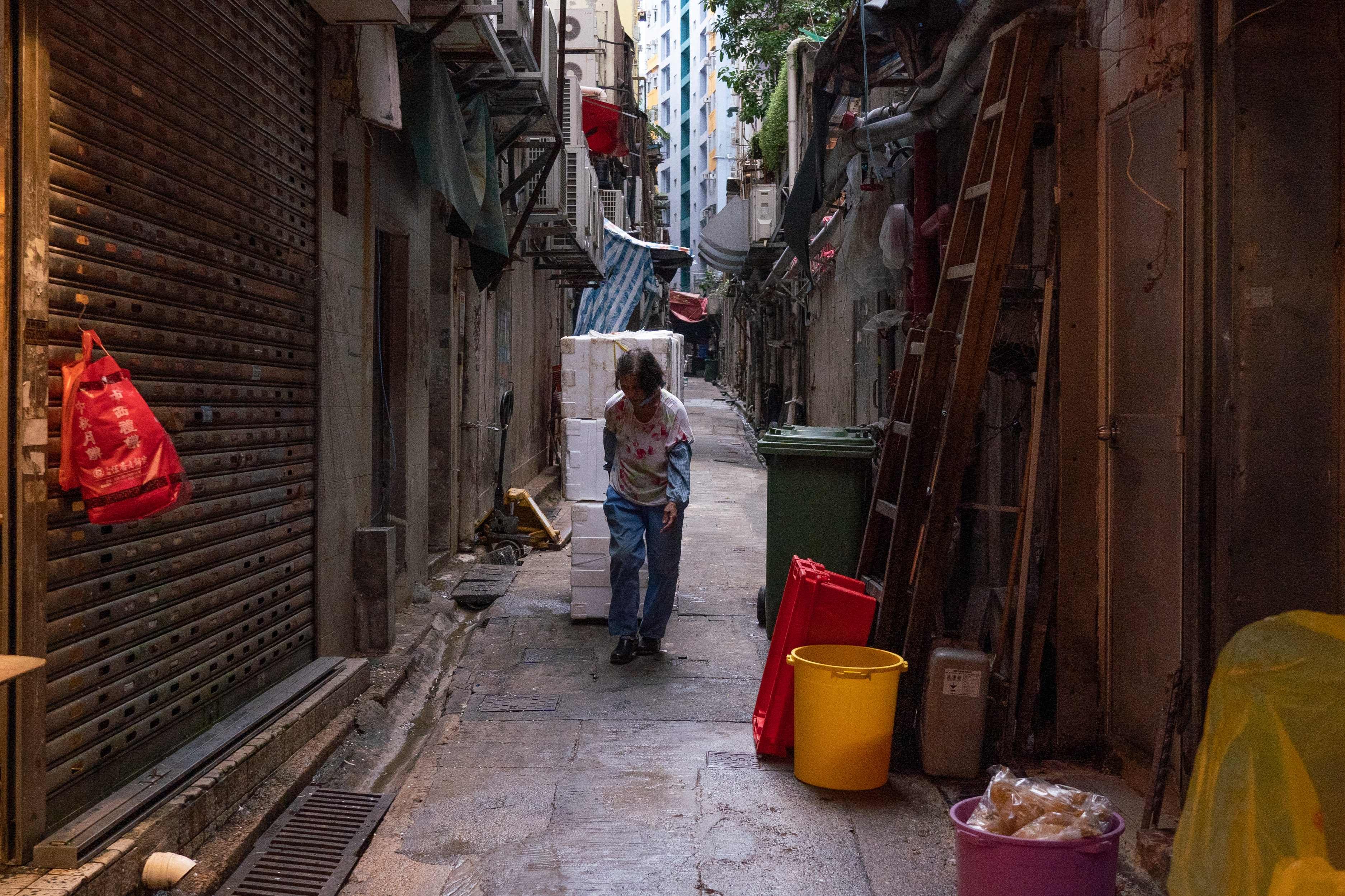 A woman pulls styrofoam boxes in an alley in Kwun Tong on October 21, 2021. Photo: AFP