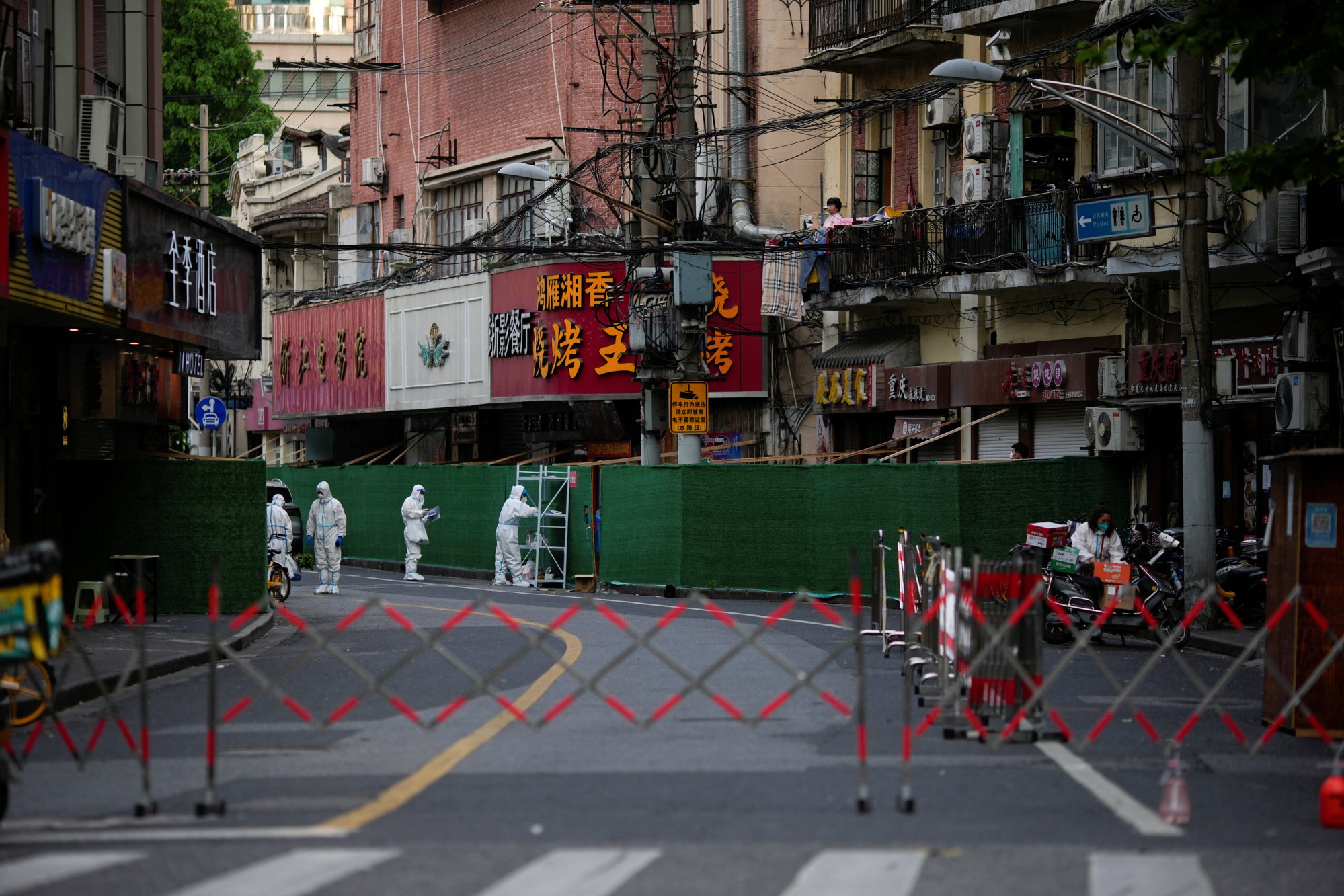 Community volunteers tending to residents’ needs in a locked down residential compound in Shanghai on May 25, 2022. Photo: Reuters.