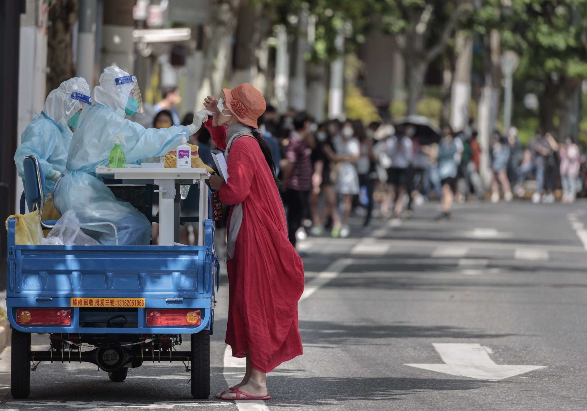 A woman took a PCR test on a new mobile testing booth made from a cargo motorcycle in Shanghai on 23 May 2022. Photo: EPA-EFE