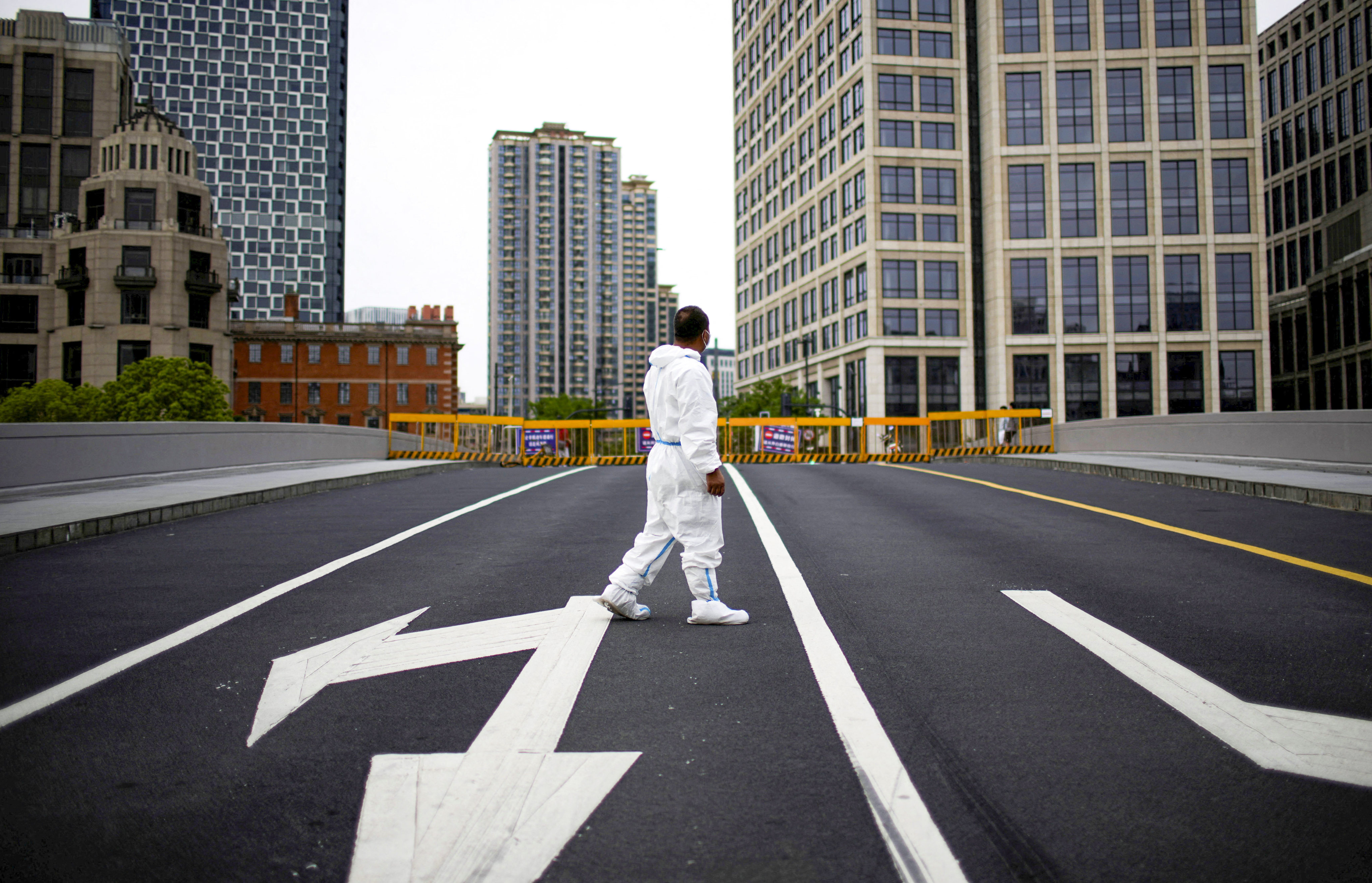 A worker in a protective suit on a closed bridge and empty roads during a citywide lockdown in Shanghai on May 18, 2022. Photo: Reuters.
