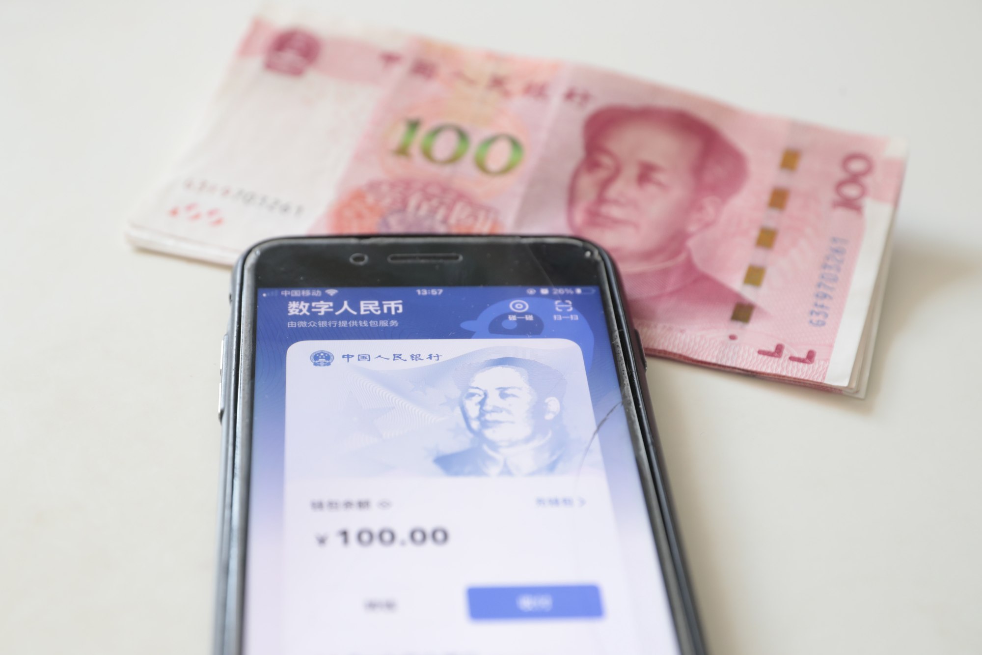 An e-CNY digital wallet is seen on a mobile phone with paper Chinese currency. Photo: EPA-EFE