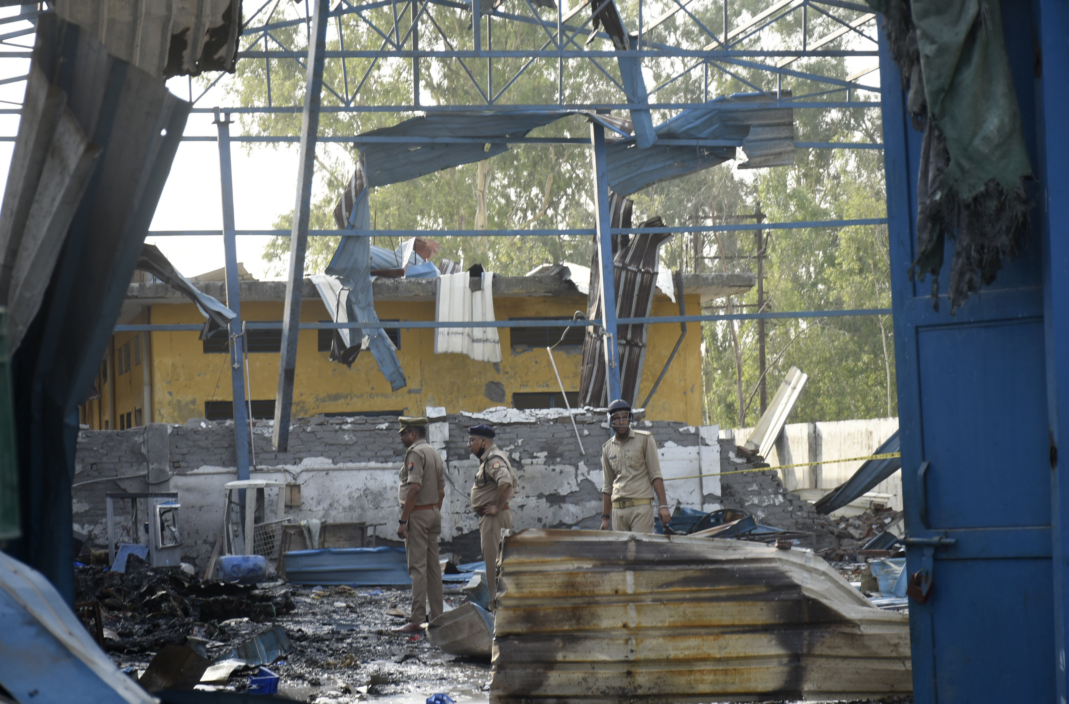 Policemen inspect the site of a fire that erupted in a chemical factory in northern India on Saturday. Photo: AP