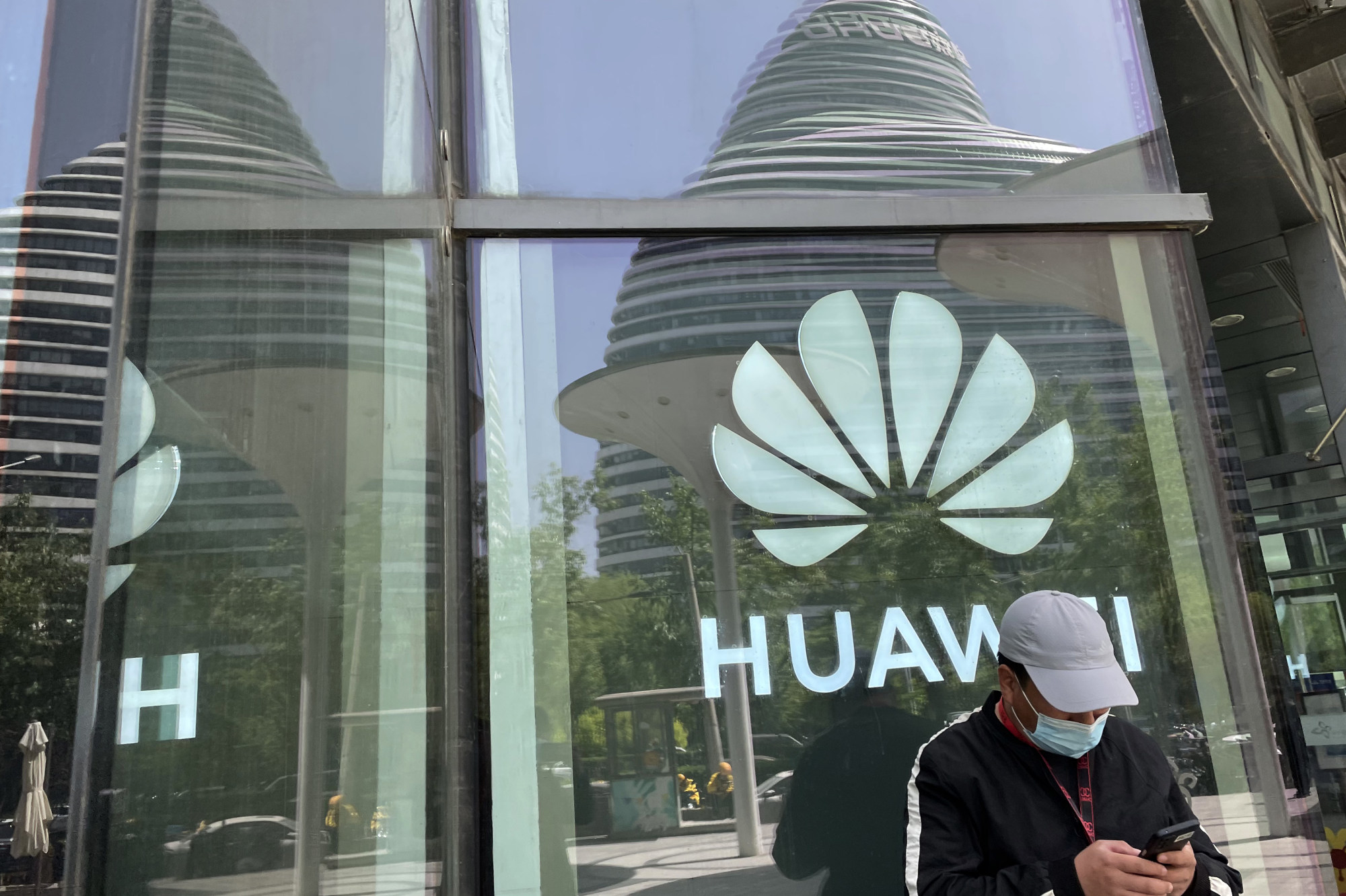 A man stands in front of a Huawei store in Beijing on April 27. The company remains a global leader in telecoms innovation, and retains a dominant market position both globally and at home. Photo: Simon Song