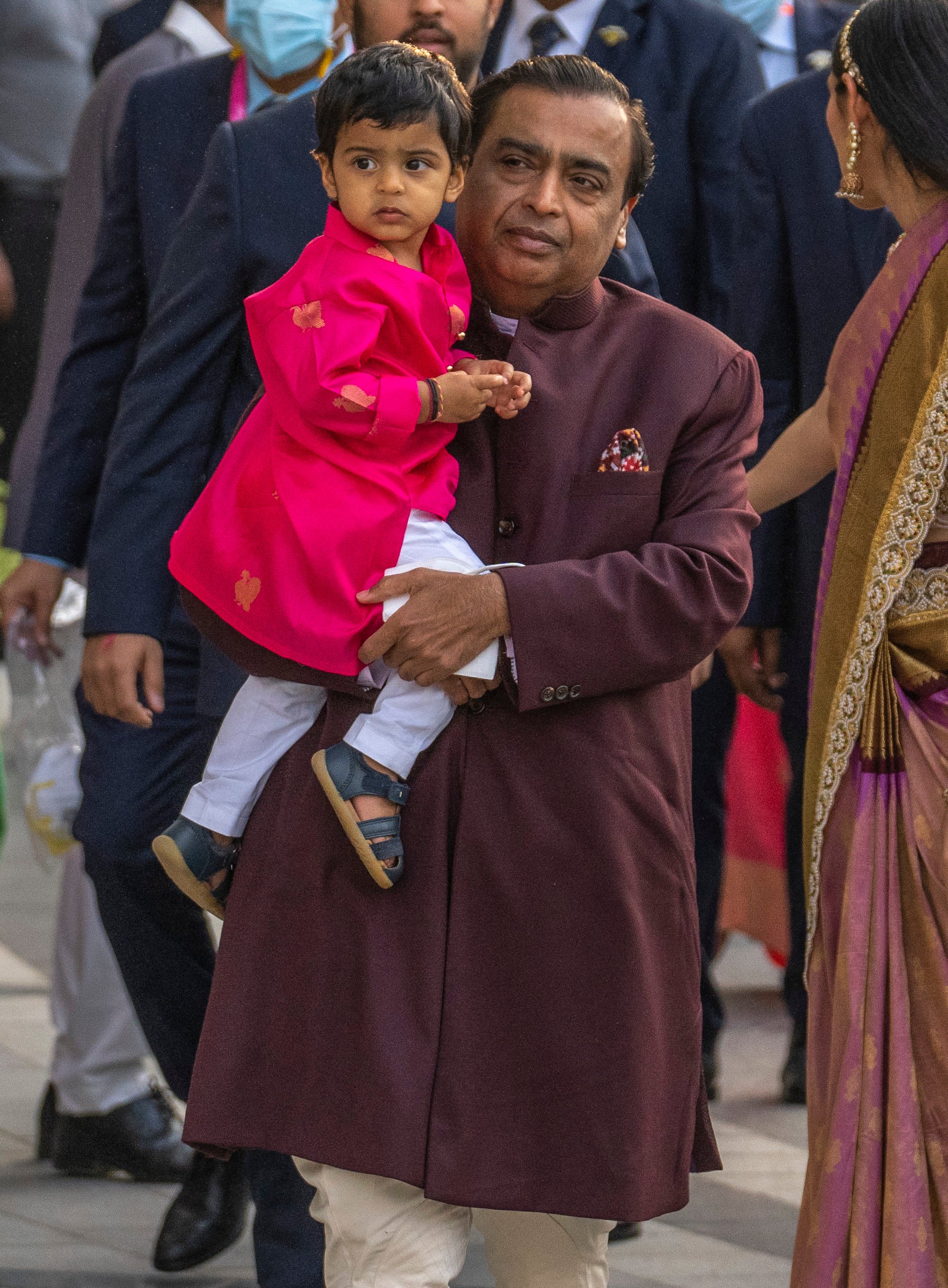 Reliance Industries Limited Chairman Mukesh Ambani carries his grandson Prithvi Akash Ambani as he arrives to attend a classical dance performance in Mumbai, India on Sunday. Photo: AP