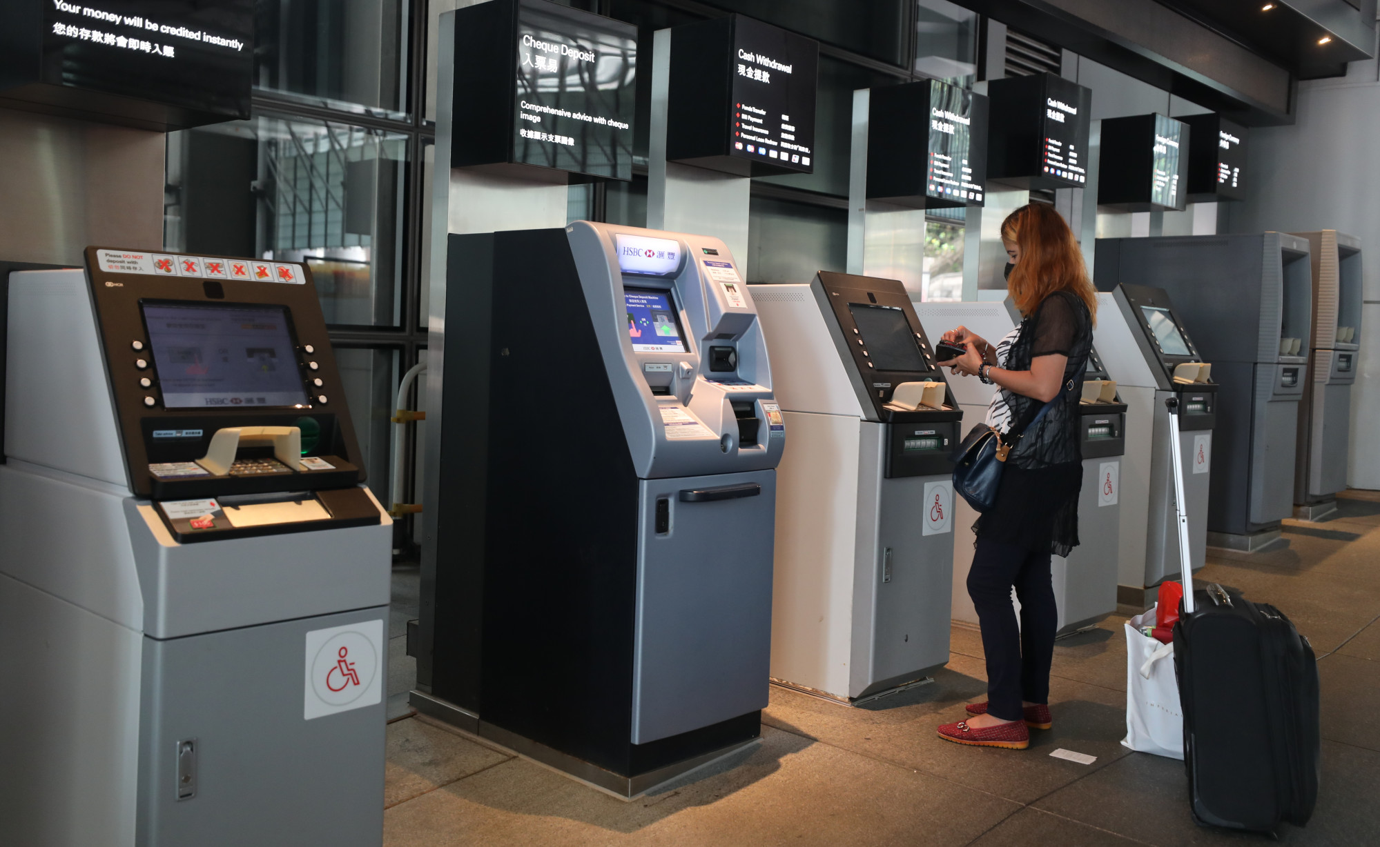 A woman withdraws cash from an ATM at HSBC headquarters in Central. Photo: Xiaomei Chen