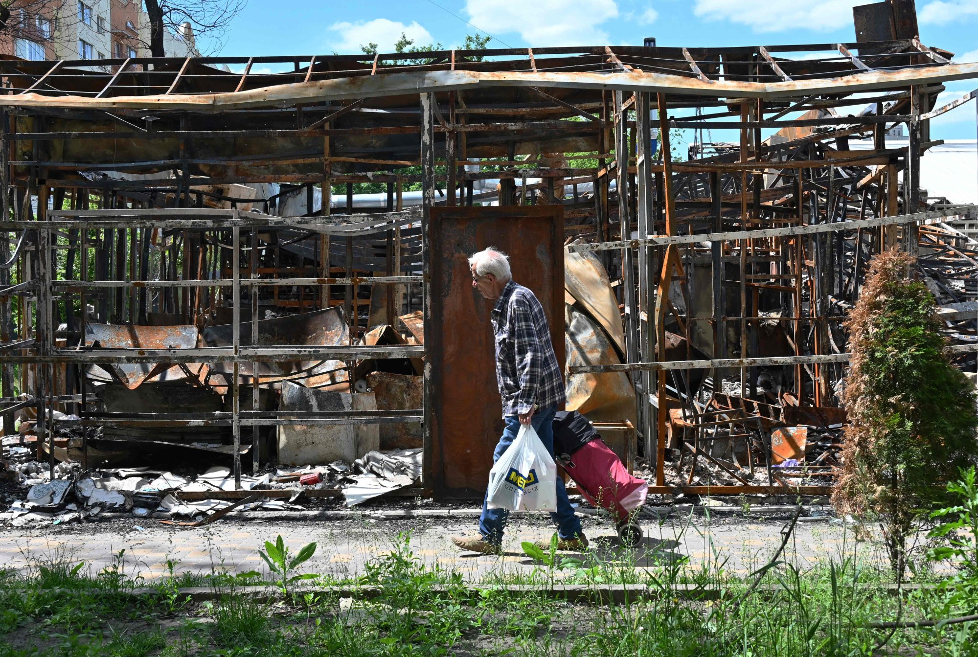 A man walks past a destroyed shop in northern outskirts of Kharkiv, Ukraine. Photo: AFP
