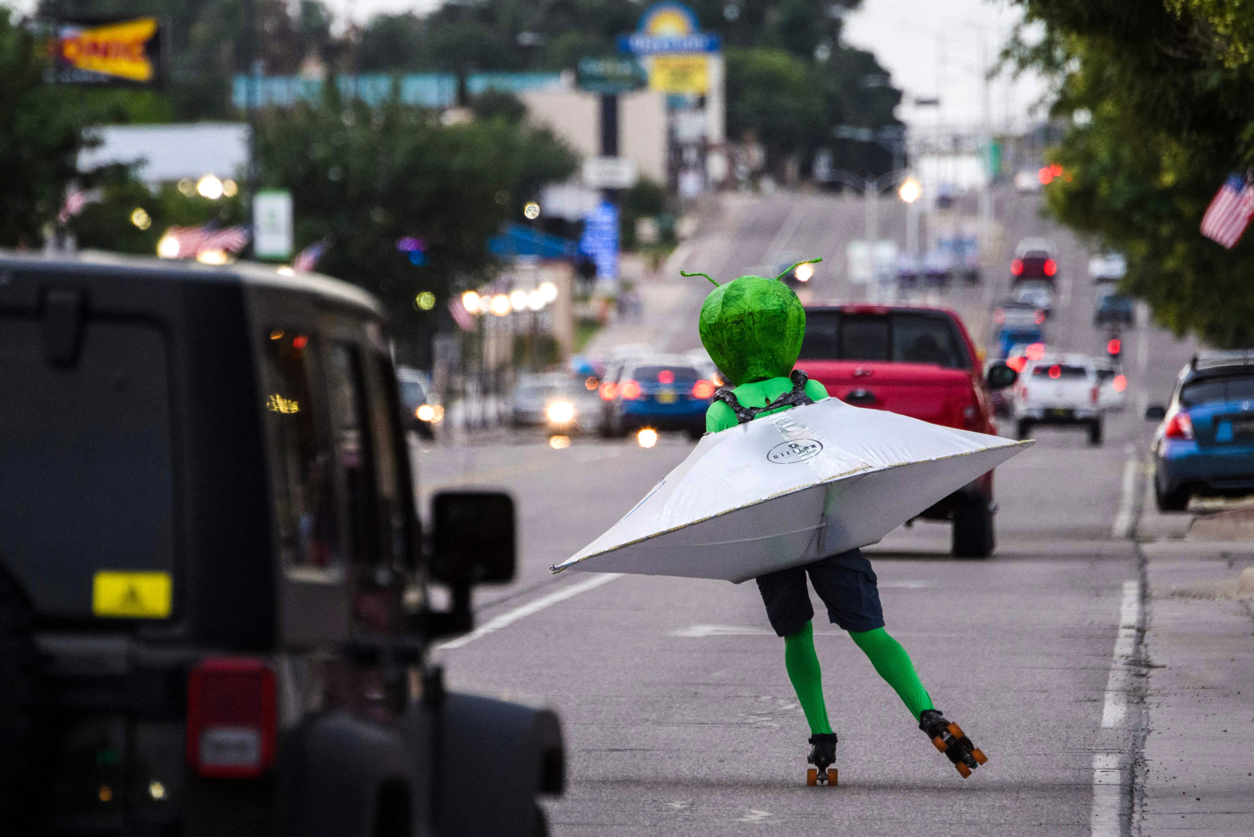 A person wearing an alien costume in a flying saucer roller skates through traffic in Roswell, New Mexico, during the UFO Festival in July 2021. Photo: AFP