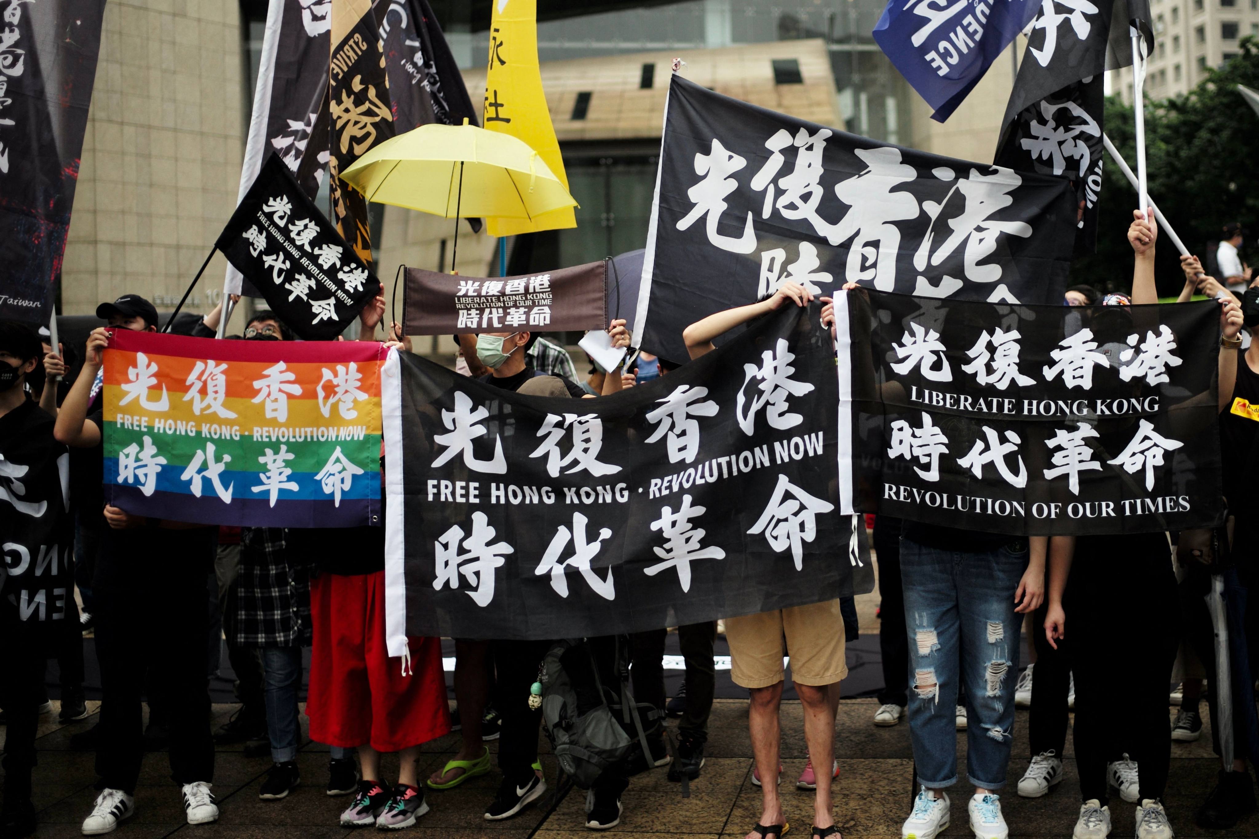 Activists hold flags that read “Free Hong Kong, Revolution Now” during a rally in Taipei on Sunday. Photo: AFP
