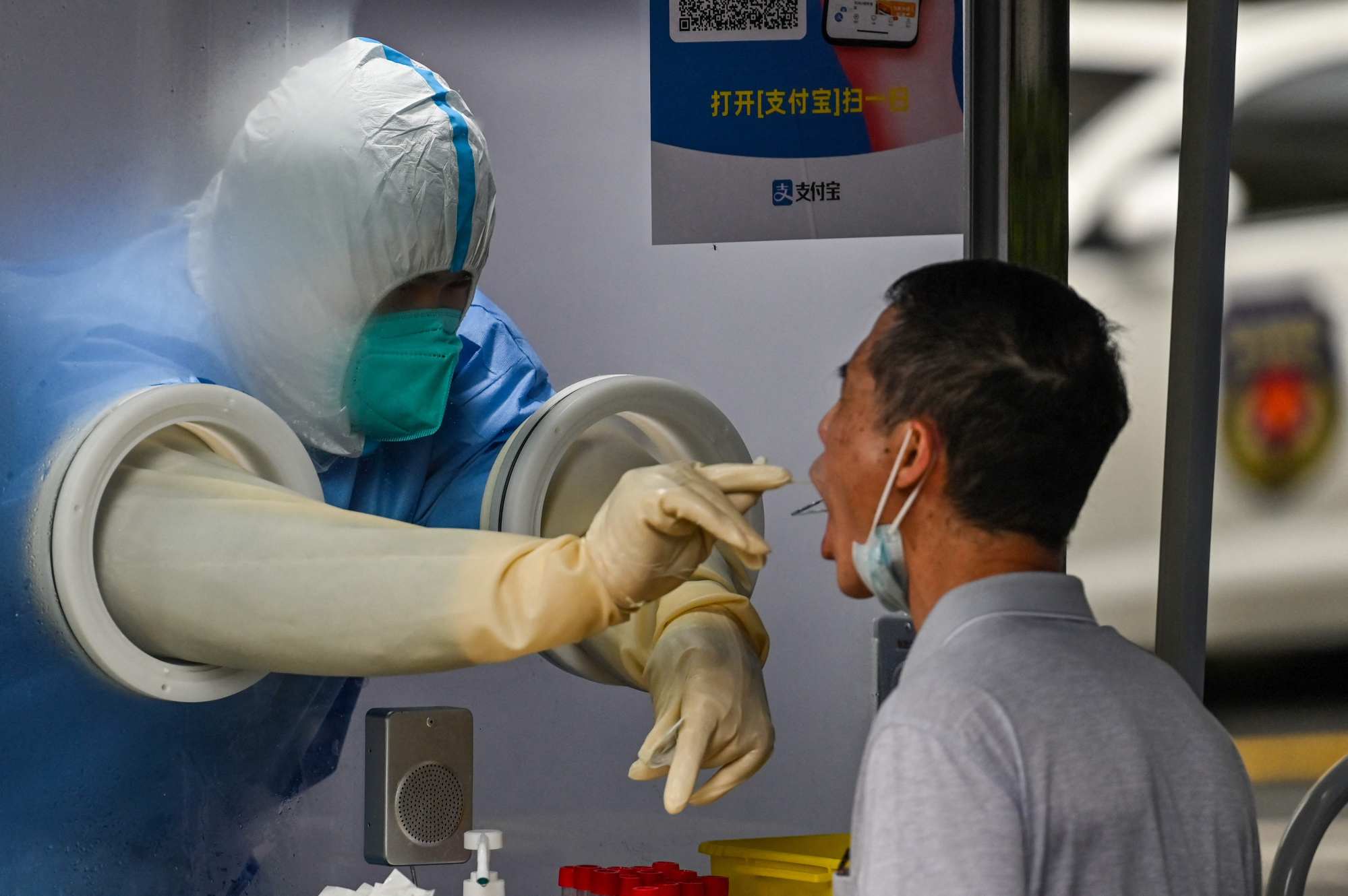 A health worker takes a swab sample from a man to test for the Covid-19 coronavirus in the Jing’an district of Shanghai on June 13, 2022. Photo: AFP