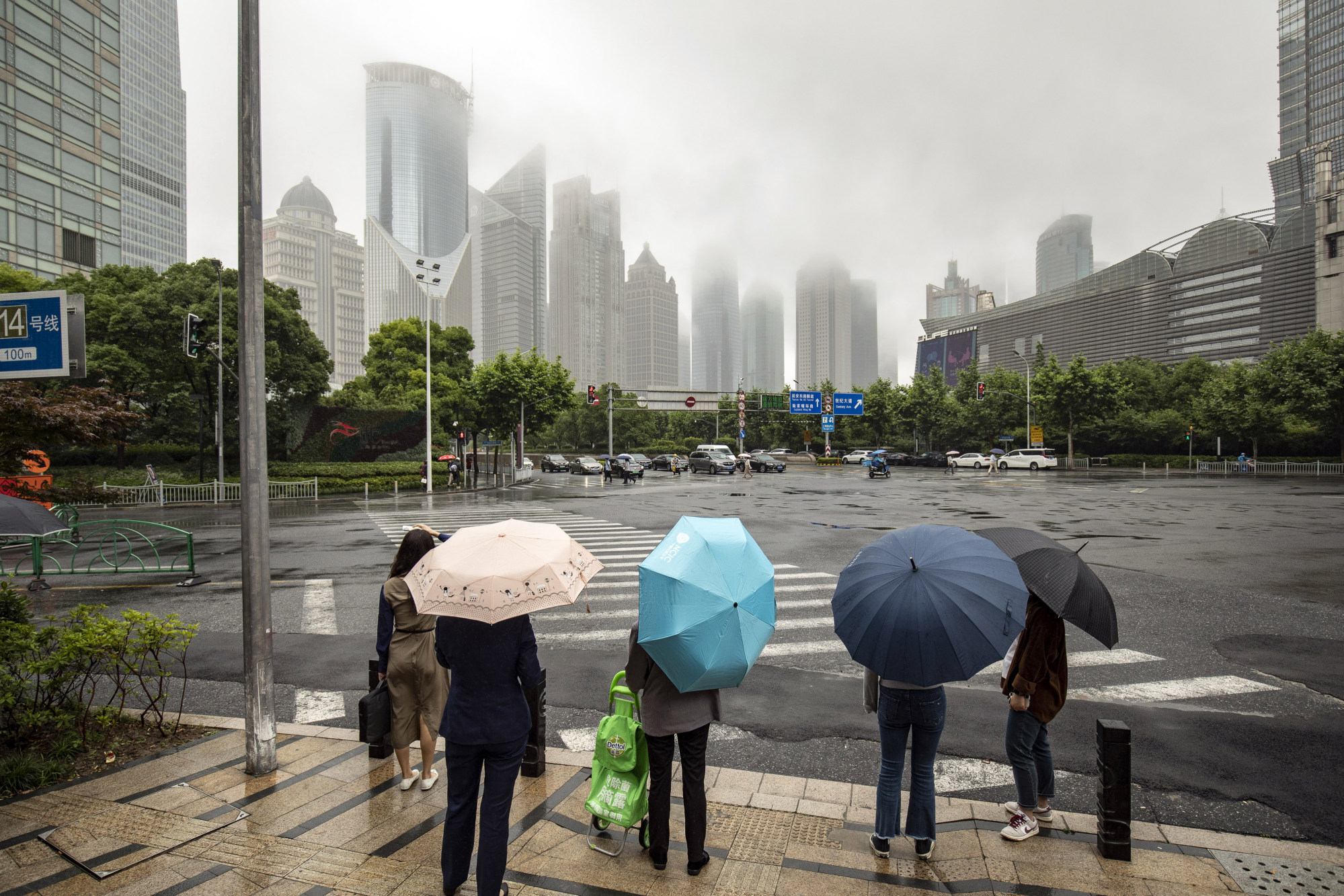 Pedestrians wait to cross a road in Pudong’s Lujiazui Financial District in Shanghai on June 13, 2022. China is starting to re-impose Covid-19 restrictions just weeks after major easing in key cities. Photo: Bloomberg