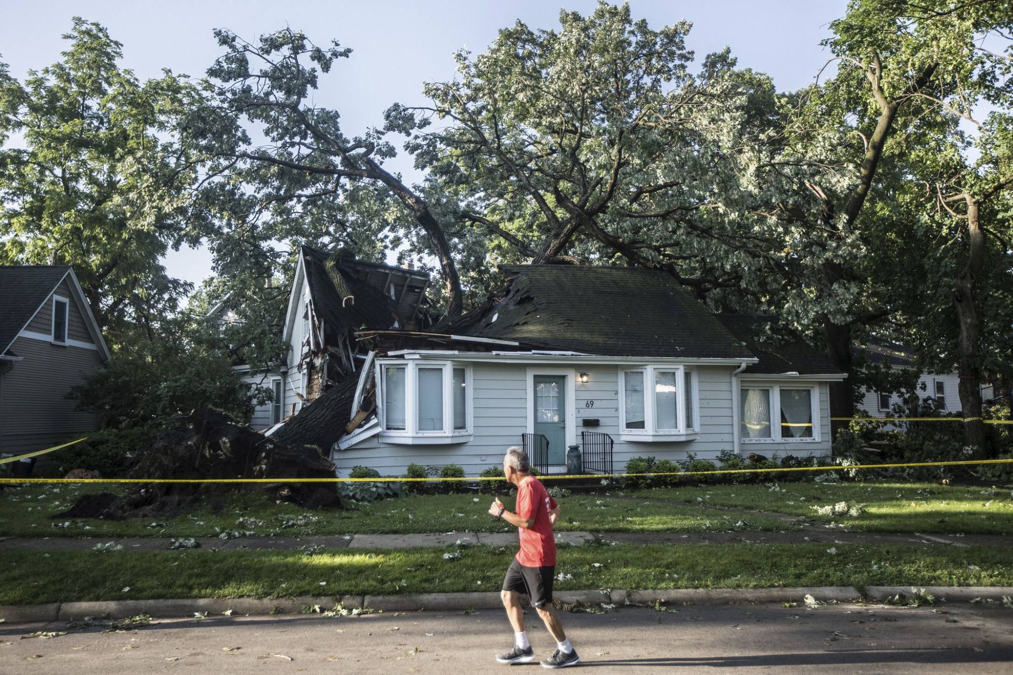 A tree crushed a home during the storm that raced across Chicago, on June 14. Photo: TNS