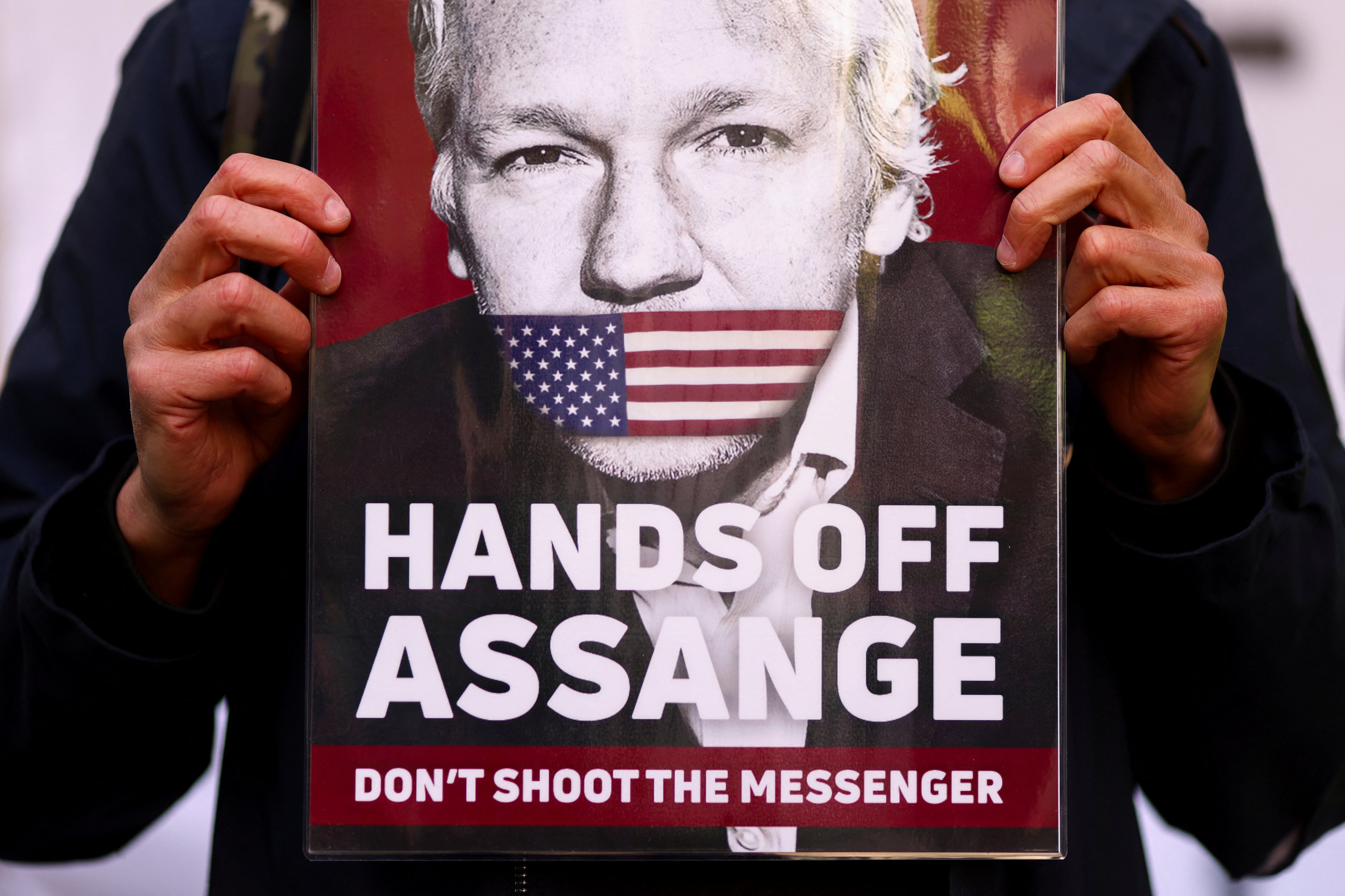 A supporter of Julian Assange displays a placard outside the Westminster Magistrates’ Court in London. Photo: Reuters