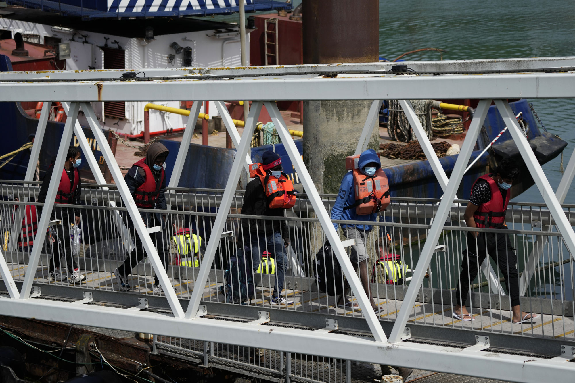 People thought to be migrants who undertook the crossing from France in small boats and were picked up in the Channel, arrive in southeast England on Friday. Photo: AP
