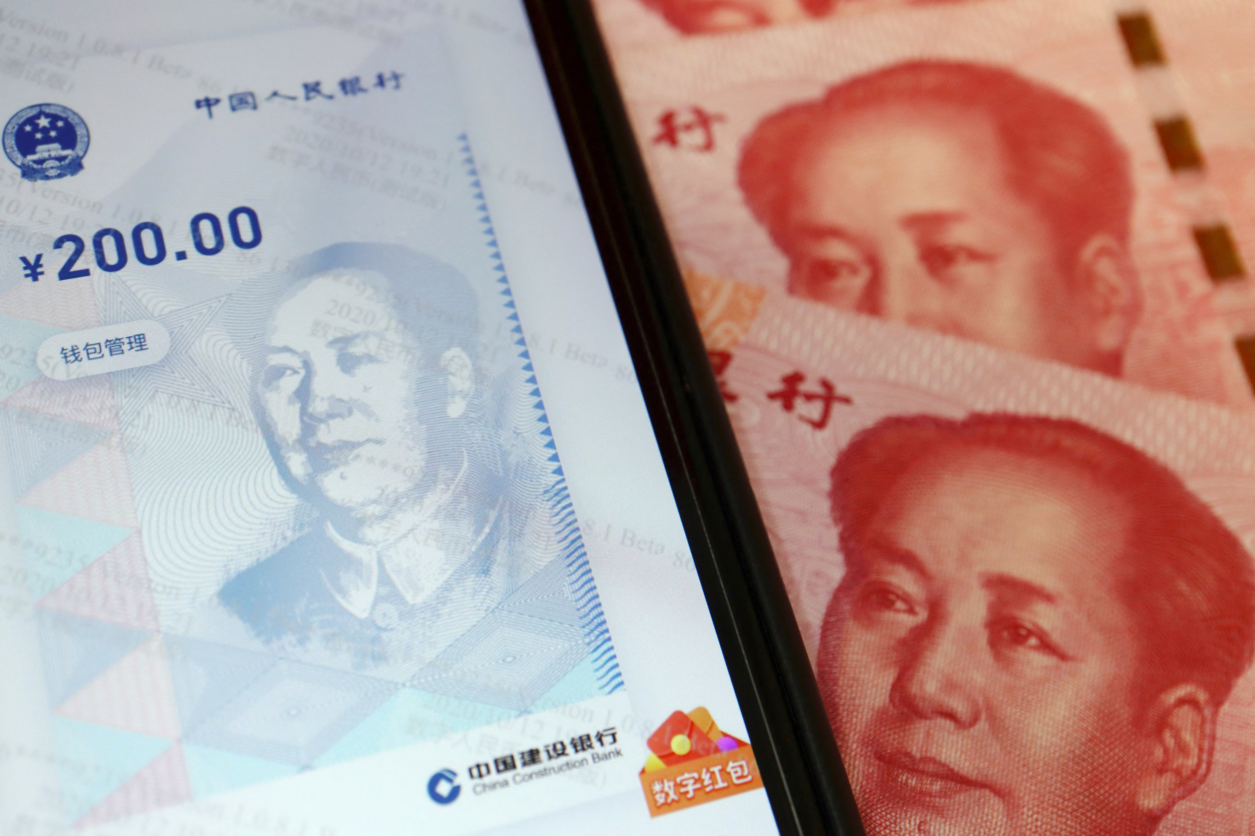 China’s official app for the digital yuan seen on a mobile phone next to 100-yuan banknotes in this illustration picture taken October 16, 2020. The digital yuan was seen as a response to cryptocurrencies, but the underlying technology is quite different. Photo: Reuters