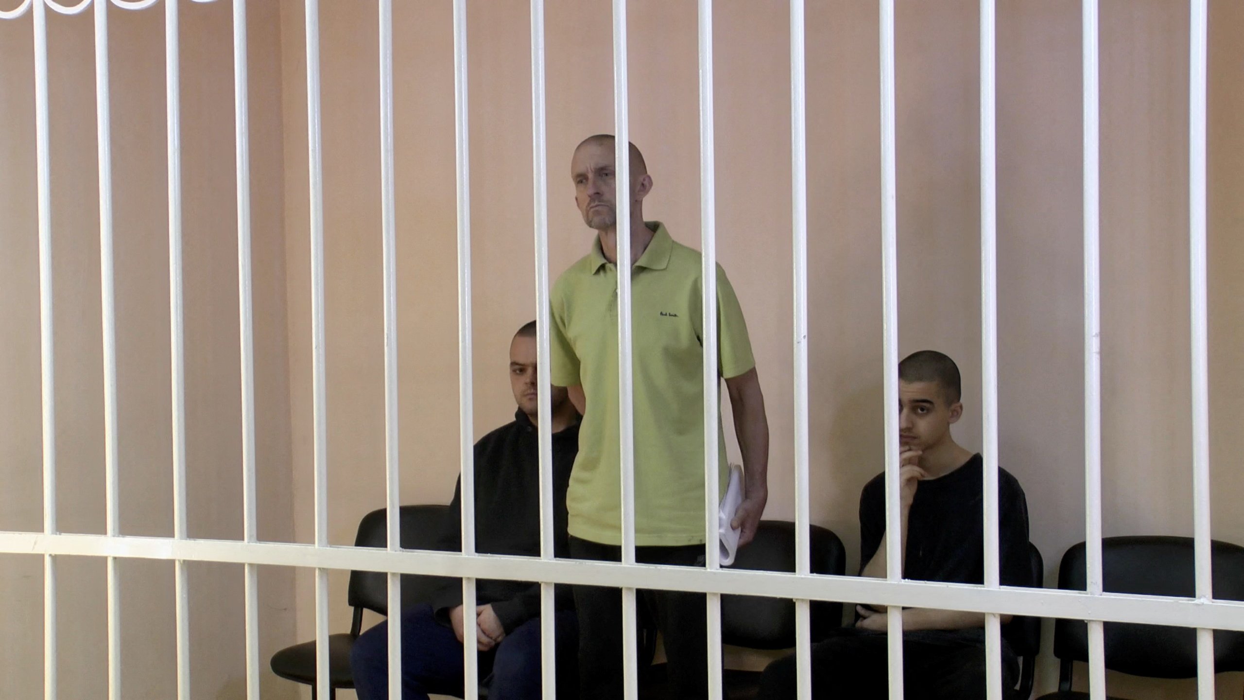 From left, Britons Aiden Aslin, Shaun Pinner and Moroccan Brahim Saadoun, captured by Russian forces during a military conflict in Ukraine, at a location given as Donetsk, Ukraine in June. Photo: Supreme Court of Donetsk People’s Republic / Handout via Reuters TV
