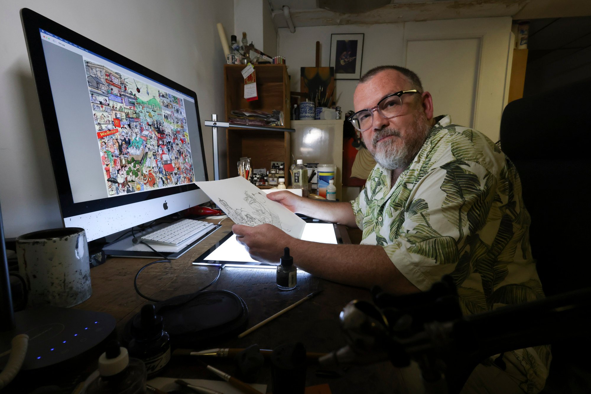 Harry Harrison with his political cartoons. Photo: Dickson Lee