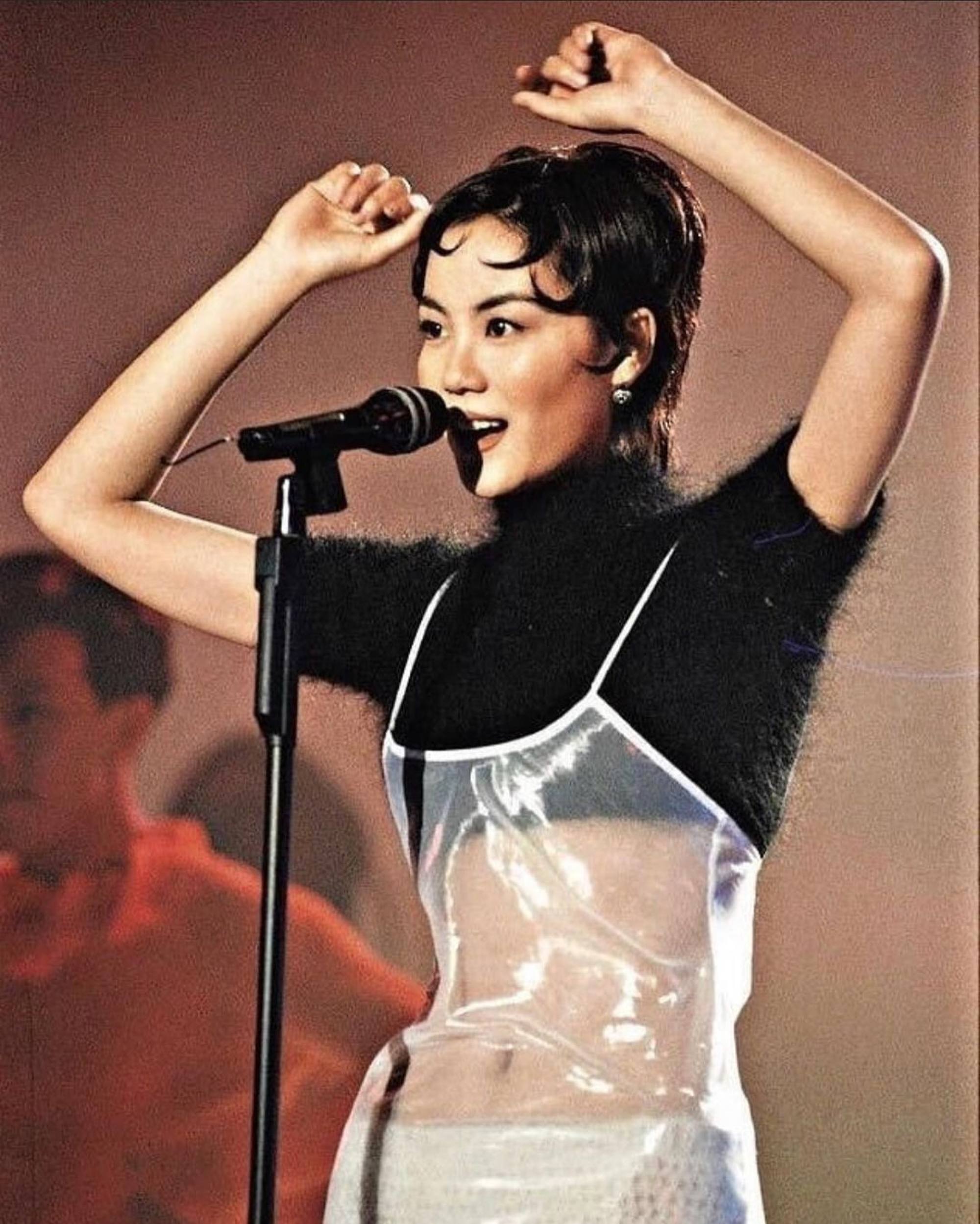 Faye Wong performs in a see-through dress paired with a black sweater crop top and knitted underwear.