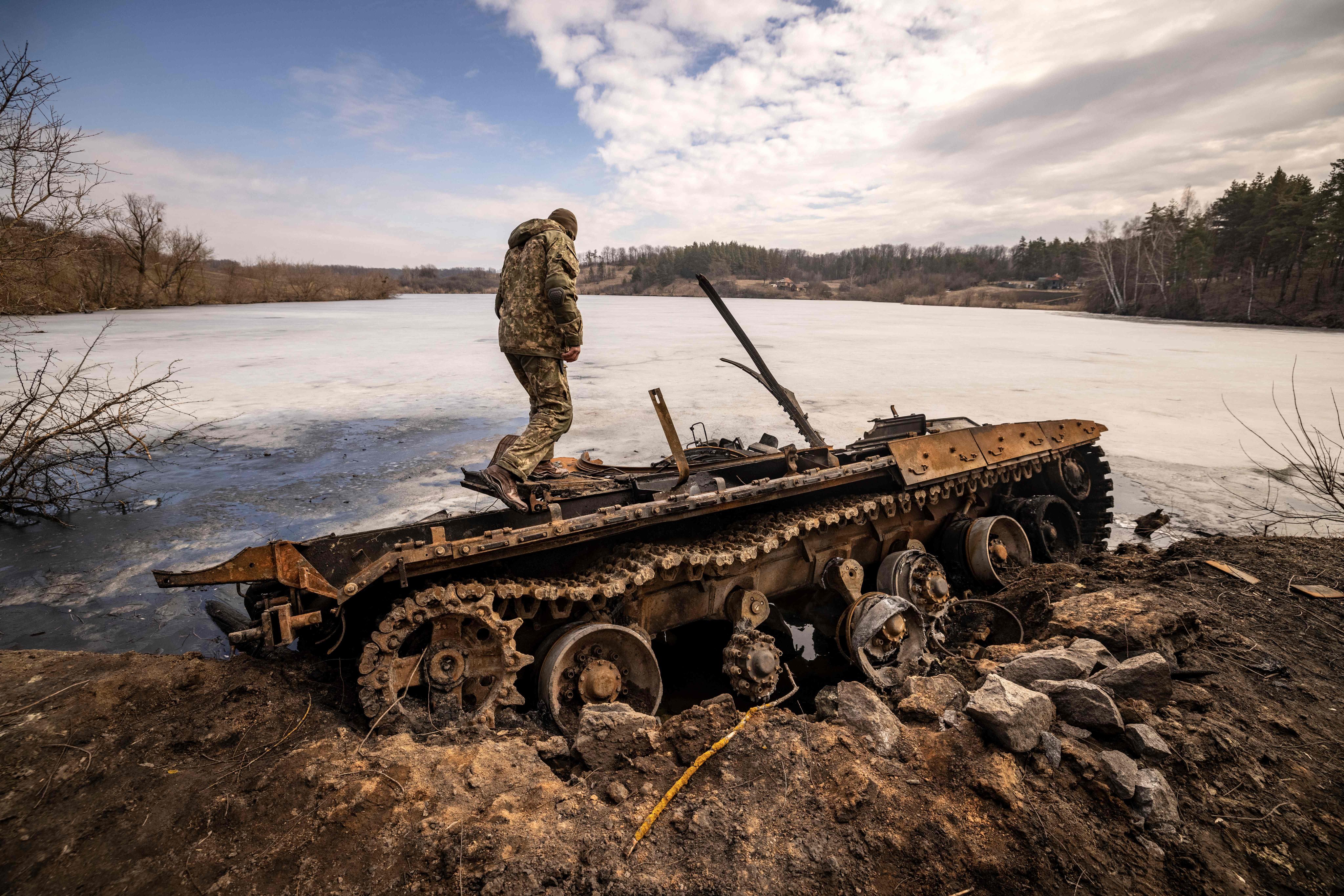 A Ukrainian serviceman stands near a destroyed Russian tank in the northeastern city of Trostyanets on March 29. Photo: AFP