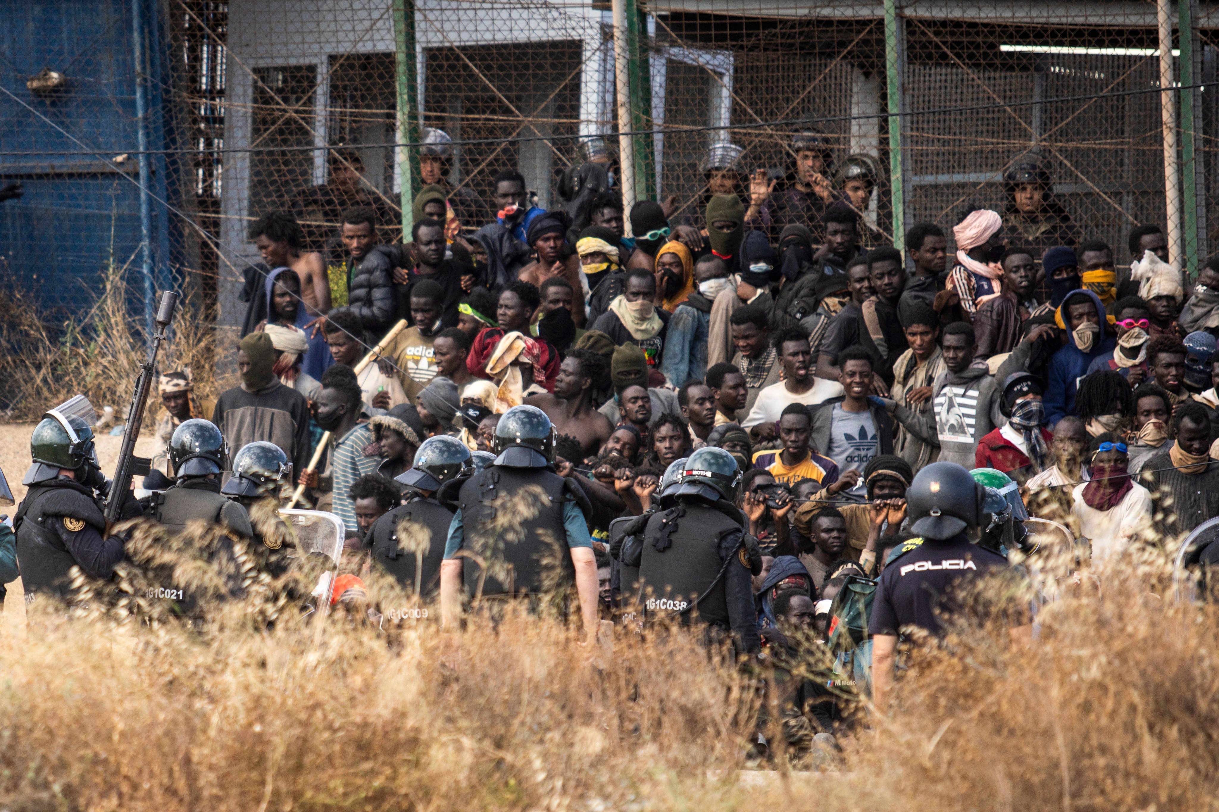 Riot police cordon off the area on Friday after migrants arrive on Spanish soil having crossed fences separating the Spanish enclave of Melilla from Morocco. Photo: AP