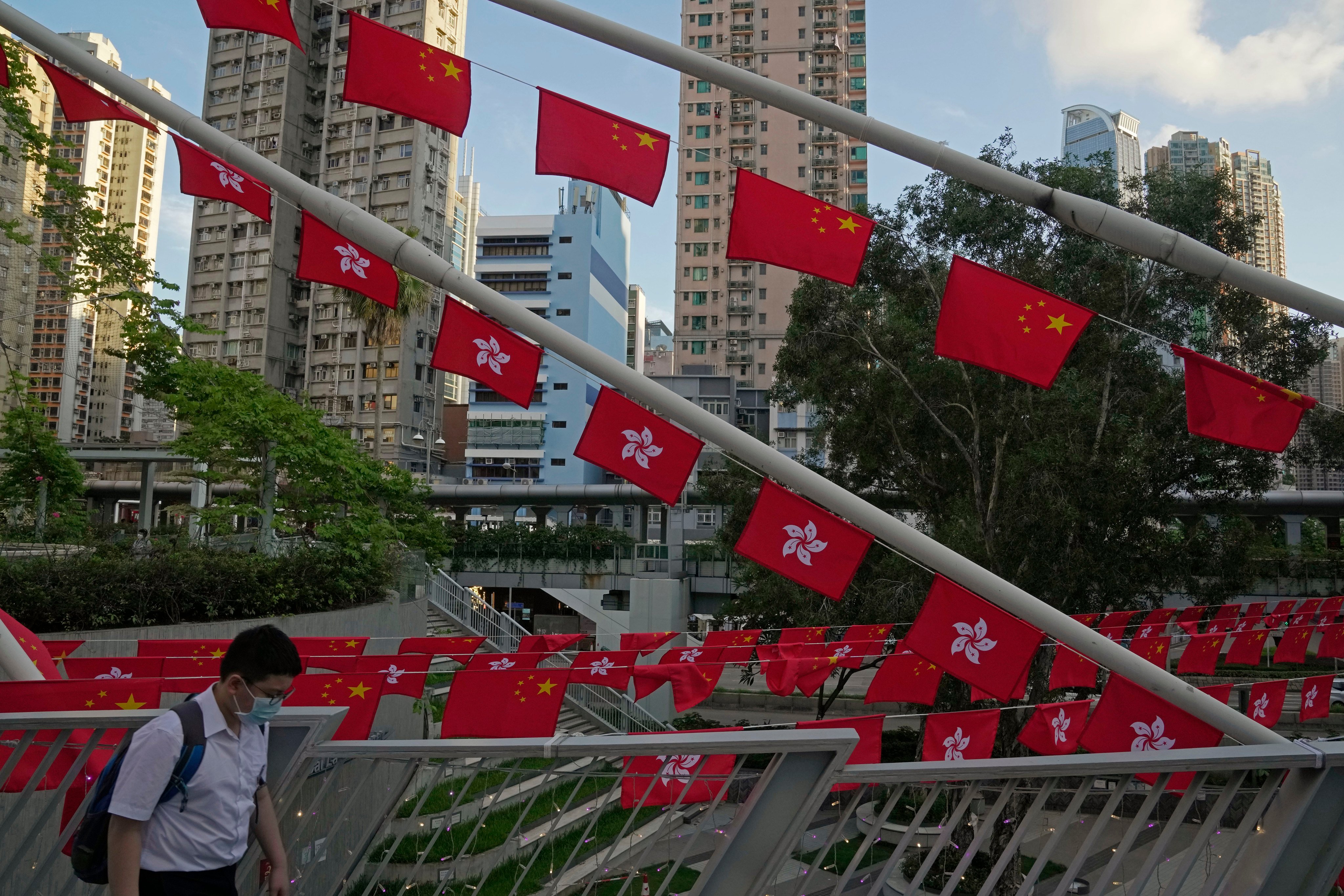 A student walks past Chinese and Hong Kong flags decorated to mark the 25th anniversary of Hong Kong handover. Photo: AP
