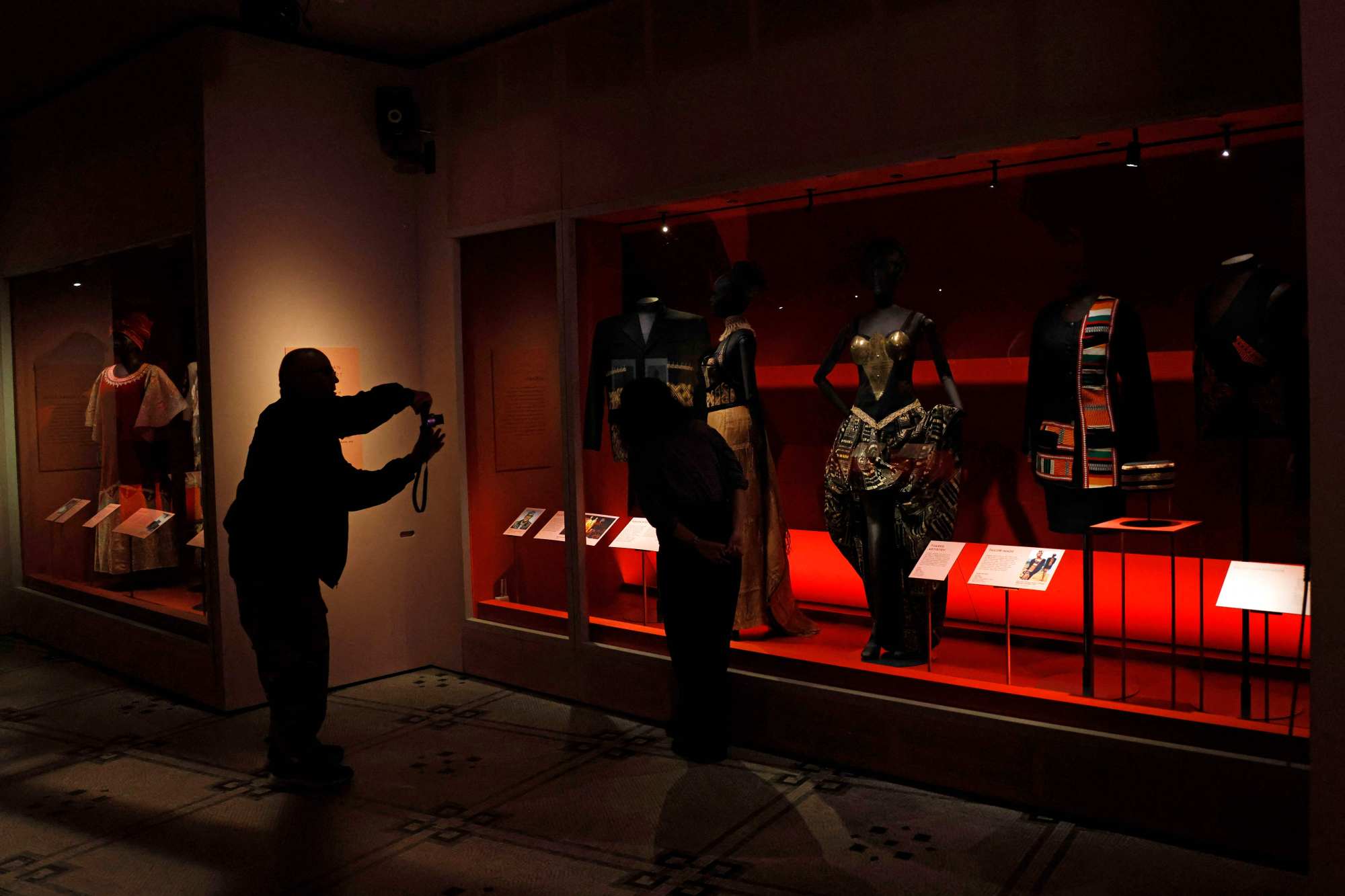 A man takes a picture of the dress known as “Tuareg Artistry” designed by Alphadi. Photo: AFP