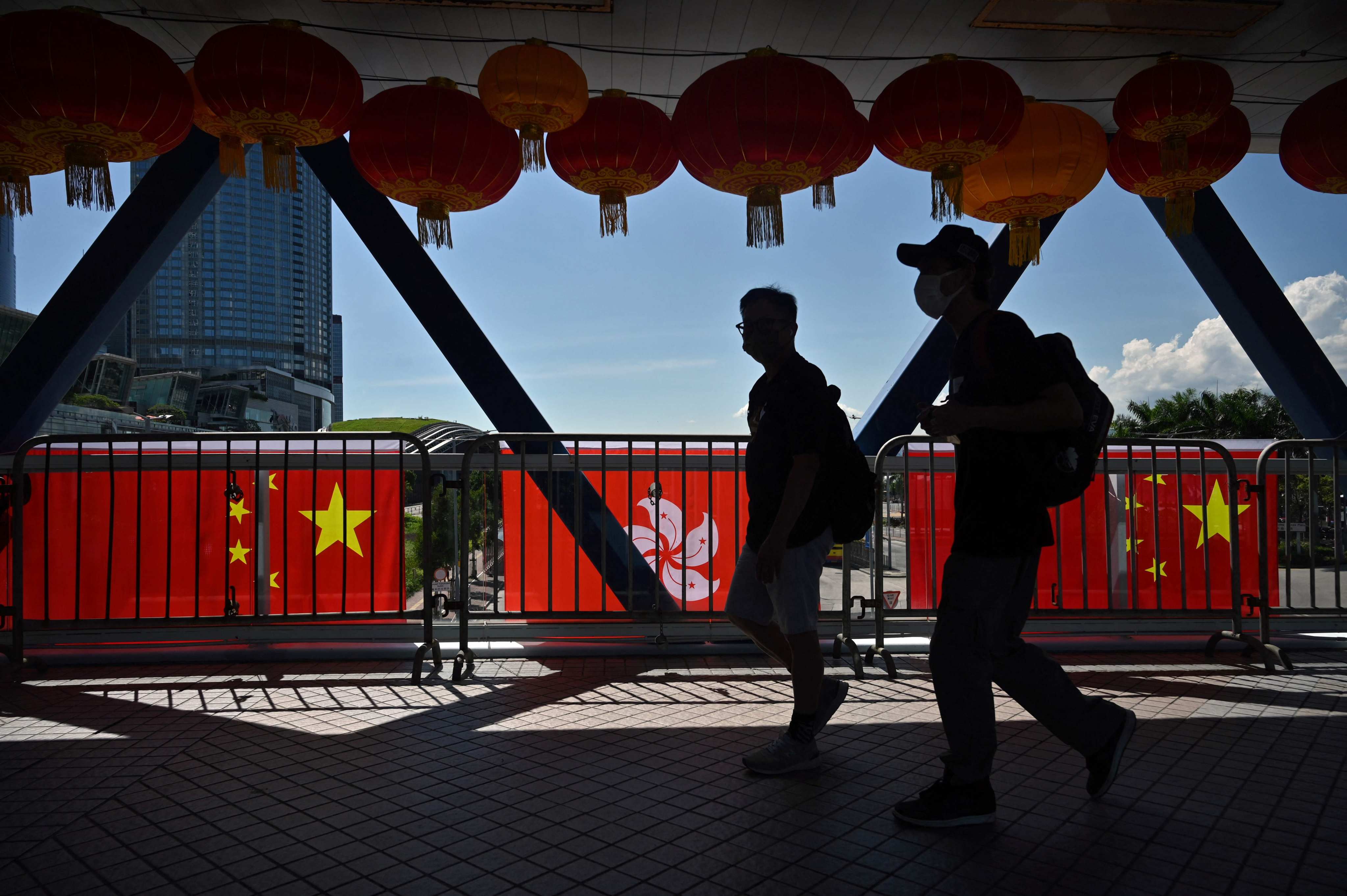 People walk past Hong Kong and China flags, hung to mark the 25th anniversary of the establishment of the Hong Kong Special Administrative Region, in Central on June 28. Photo: AFP