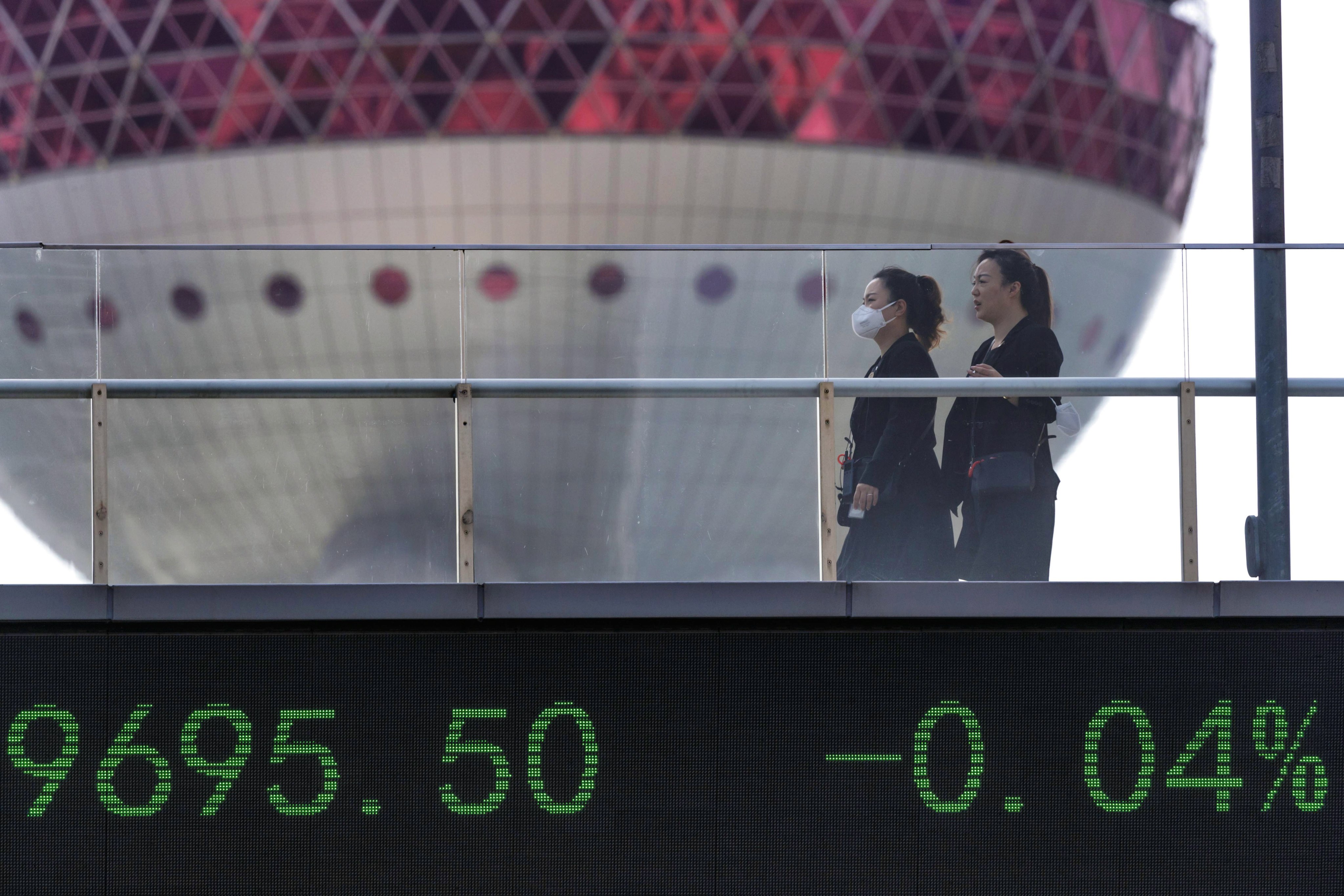 People walk across a bridge featuring the latest stock exchange data in Lujiazui, mainland China’s largest financial zone, in Shanghai, on June 8. Photo: EPA-EFE