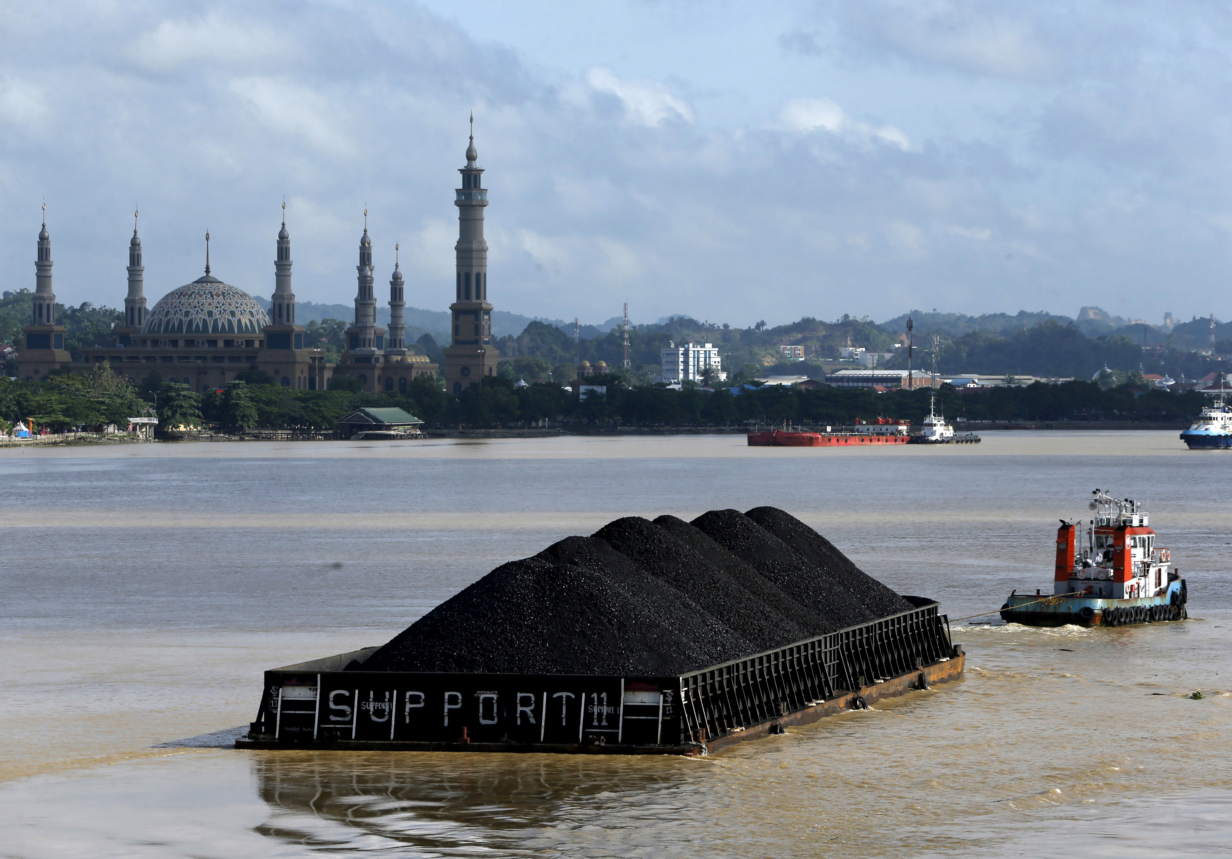 A tug boat pulls a coal barge along a river in Indonesia’s East Kalimantan province. Photo: Reuters