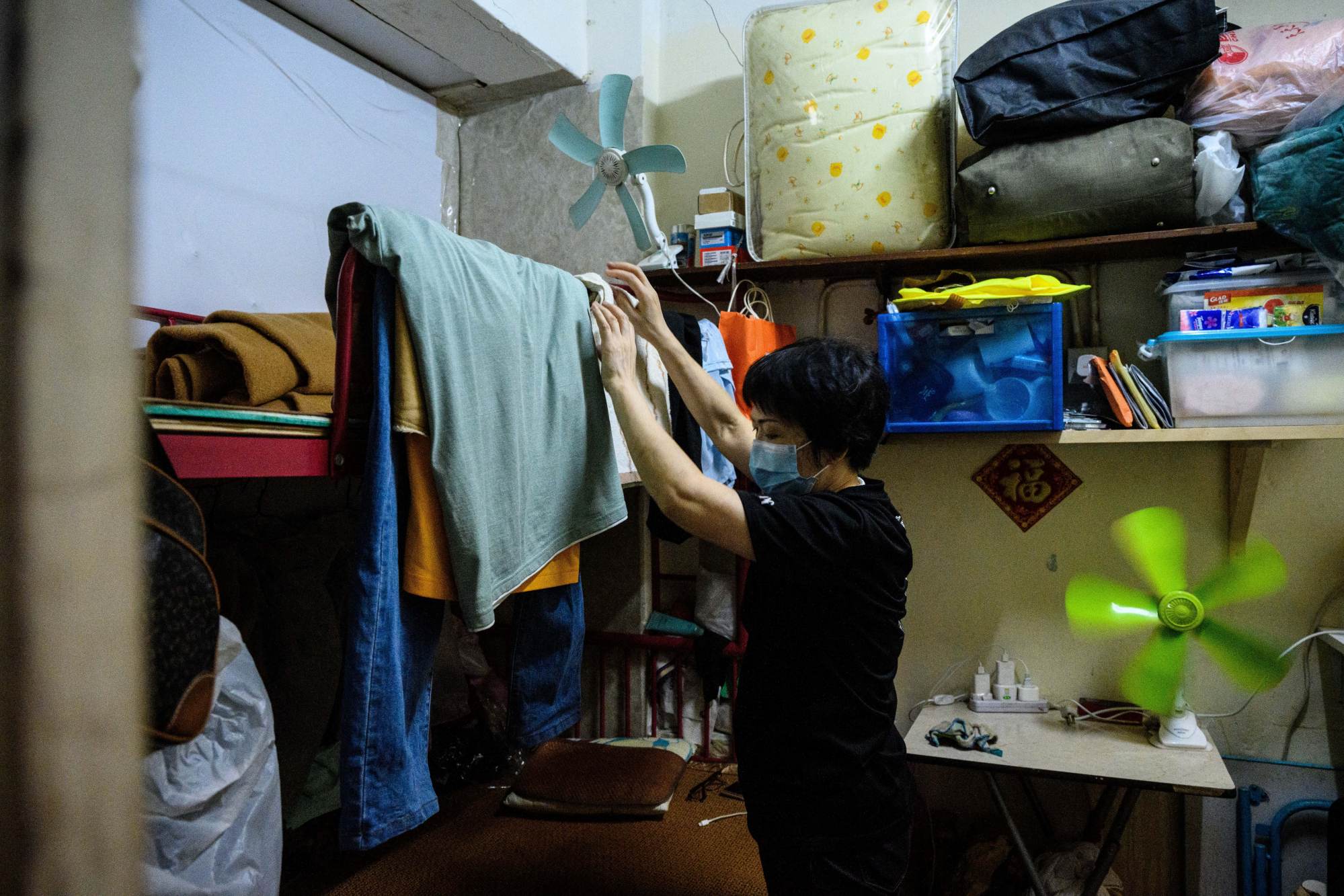 A woman in her 50 sq ft cubicle flat in a walk-up building apartment that has been subdivided into six cubicles. Photo: AFP