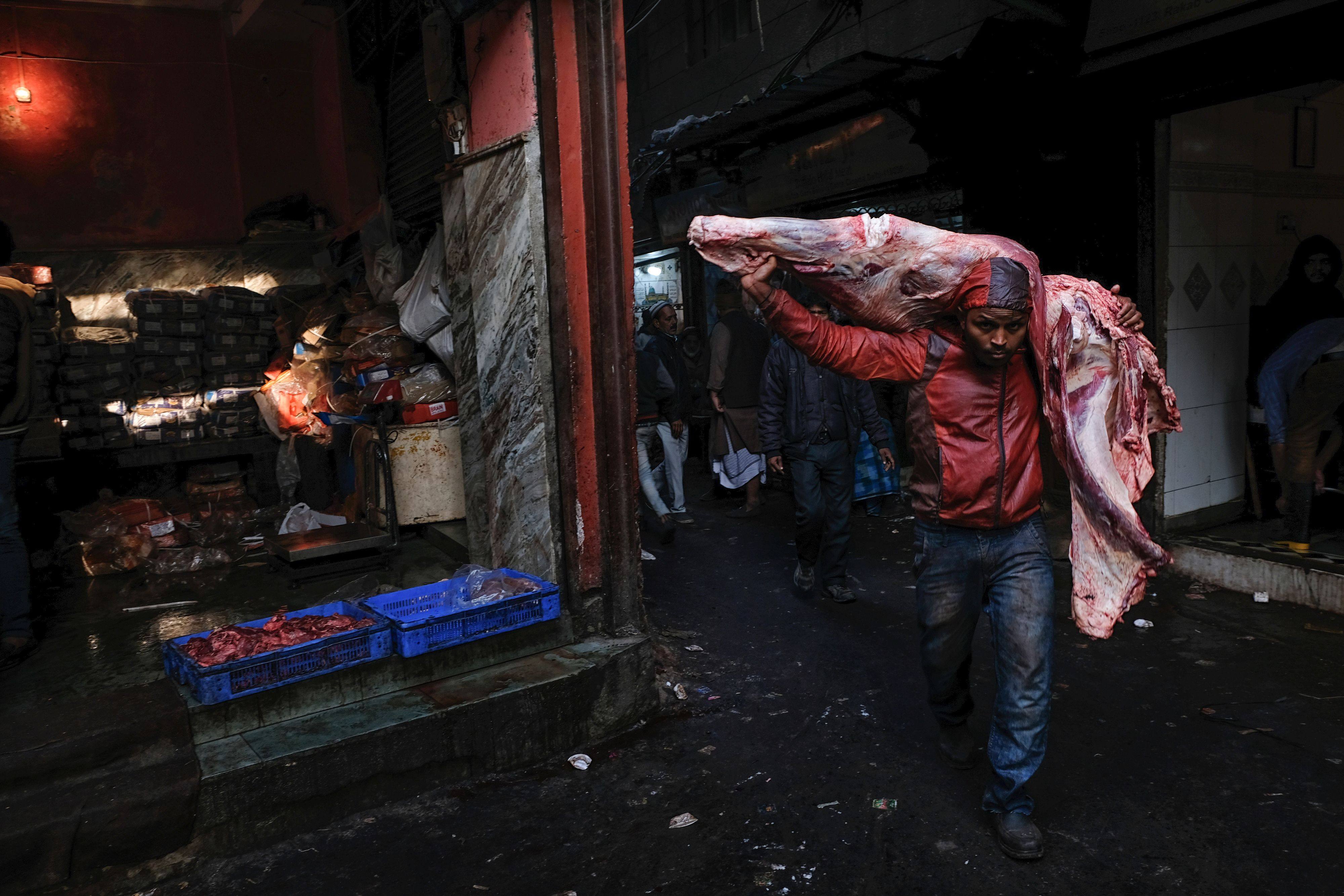 A worker carries a buffalo carcass on his shoulders at a meat market in New Delhi. File photo: AFP 