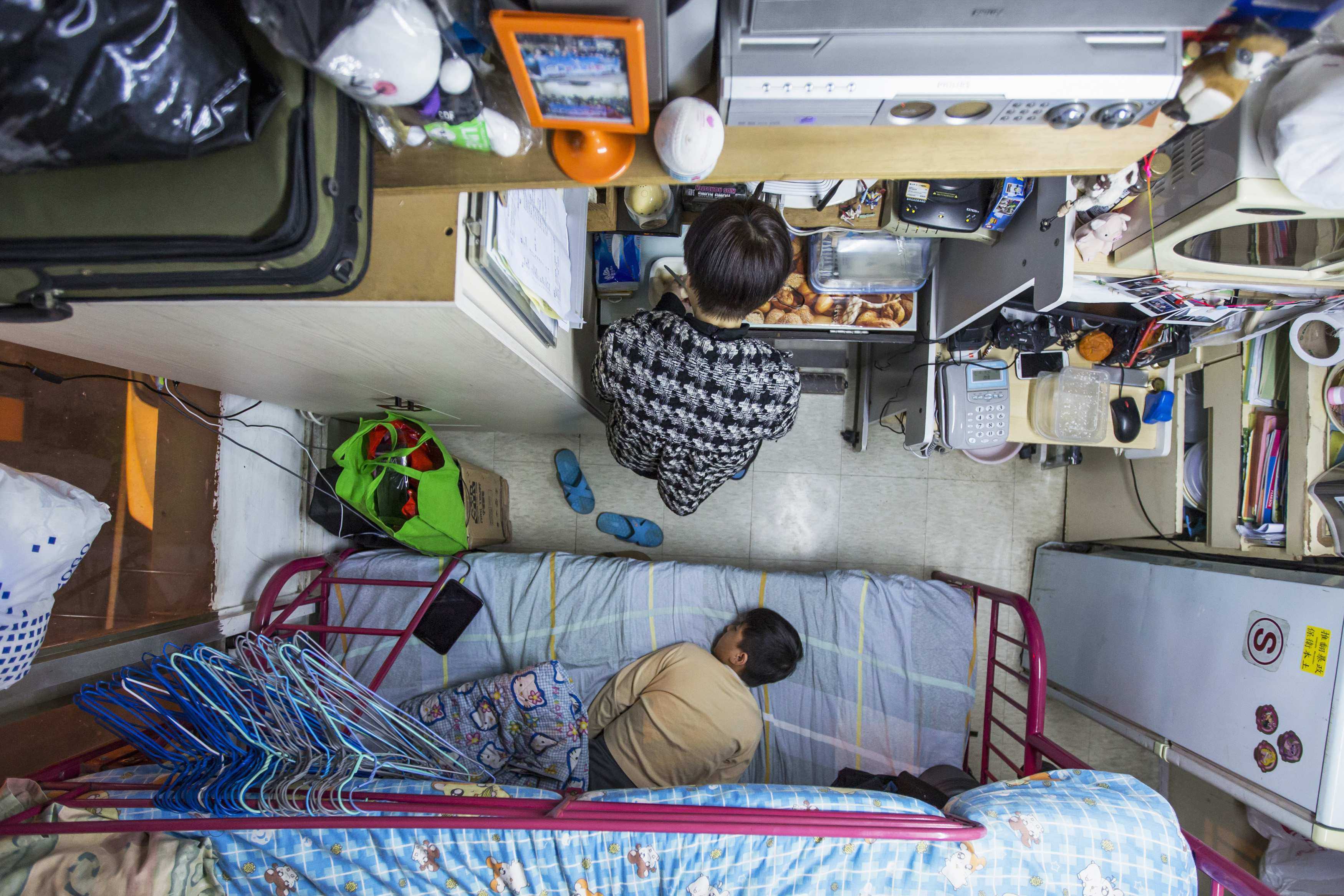 A woman and her son in their 60 sq ft subdivided flat in Hong Kong. It’s time to provide Hongkongers proper housing, Luisa Tam writes. Photo: Reuters