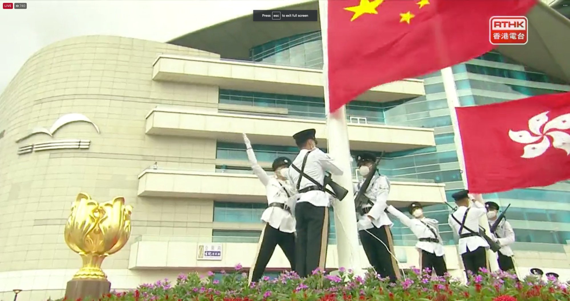Officers raise the national and city flags with a No 3 typhoon warning signal in force. Photo: RTHK