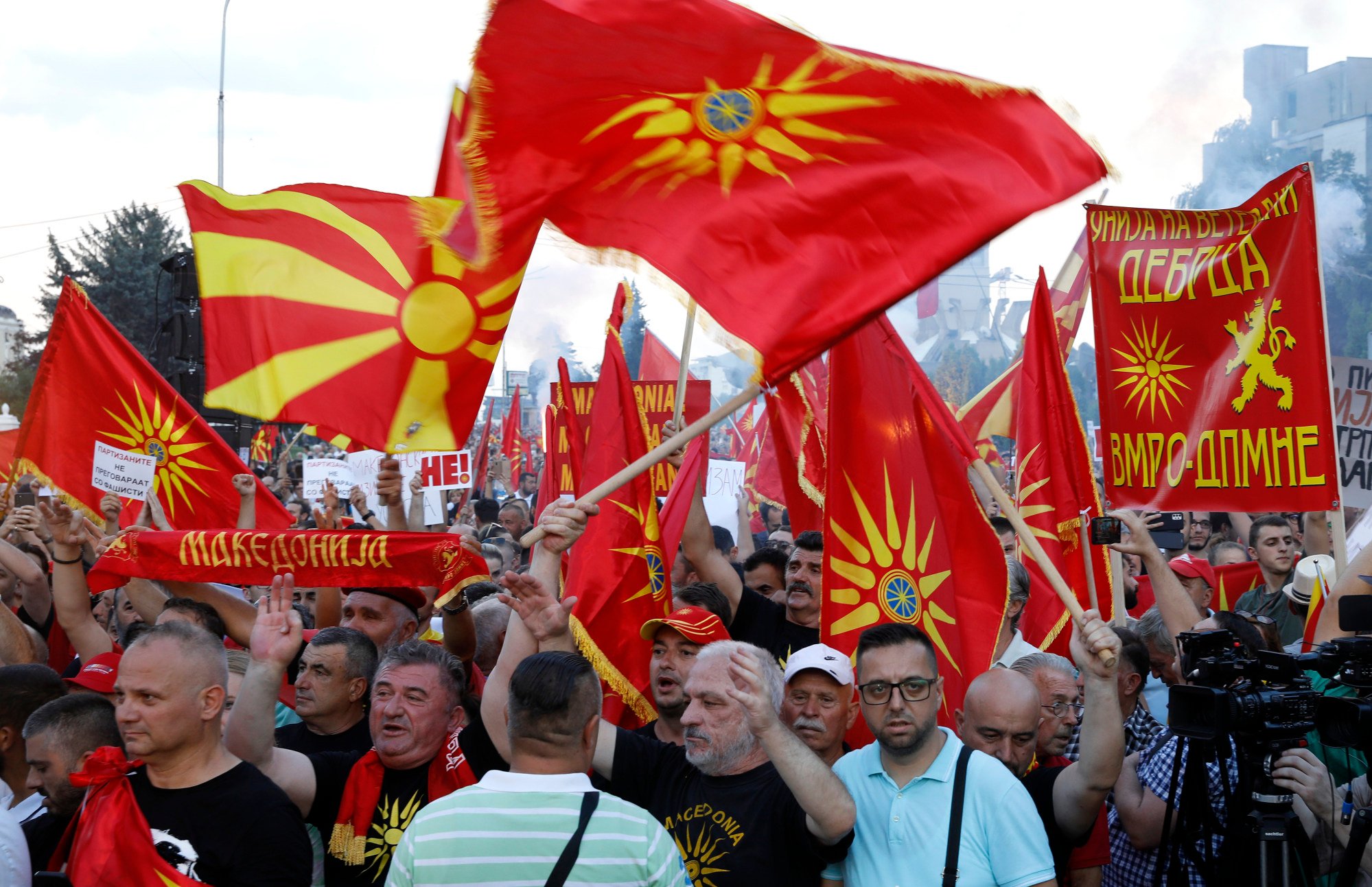 People wave the old and the current national flags of Macedonia as they attend a protest in front of the government building in Skopje, North Macedonia on Saturday. Photo: AP
