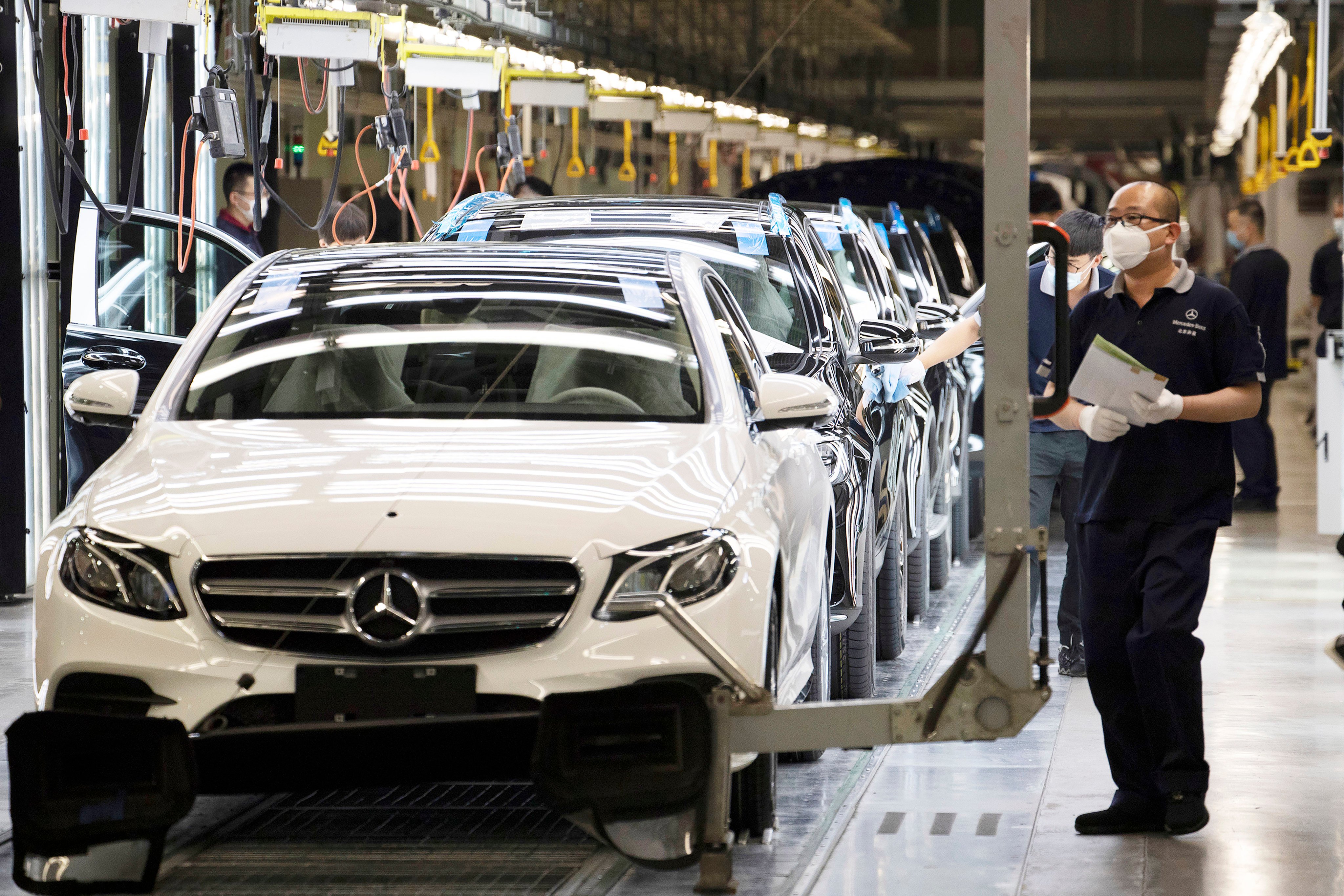 Workers inspect newly assembled cars at a factory of Beijing Benz Automotive Company, a German joint venture in China for Mercedes-Benz, in May 2020. Photo: AP
