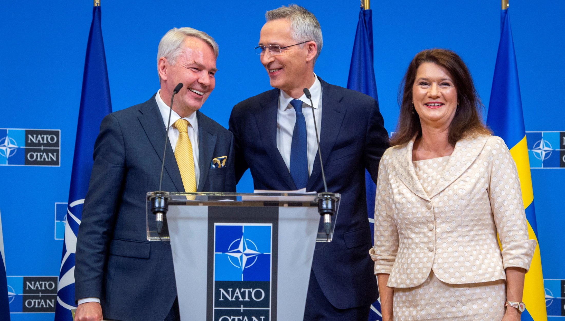 Sweden’s Foreign Minister Ann Linde and Finland’s Foreign Minister Pekka Haavisto pose for photographs with NATO Secretary General Jens Stoltenberg as they sign their countries’ accession protocols on Tuesday.  NATO/Handout via Reuters