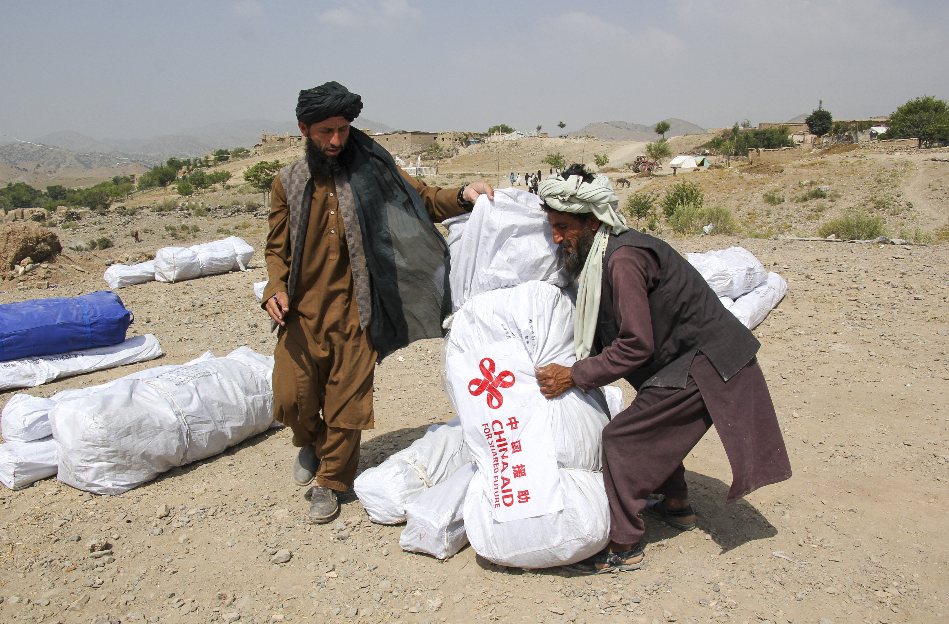 Men in eastern Afghanistan carry earthquake relief supplies from China on July 2. Photo: Xinhua
