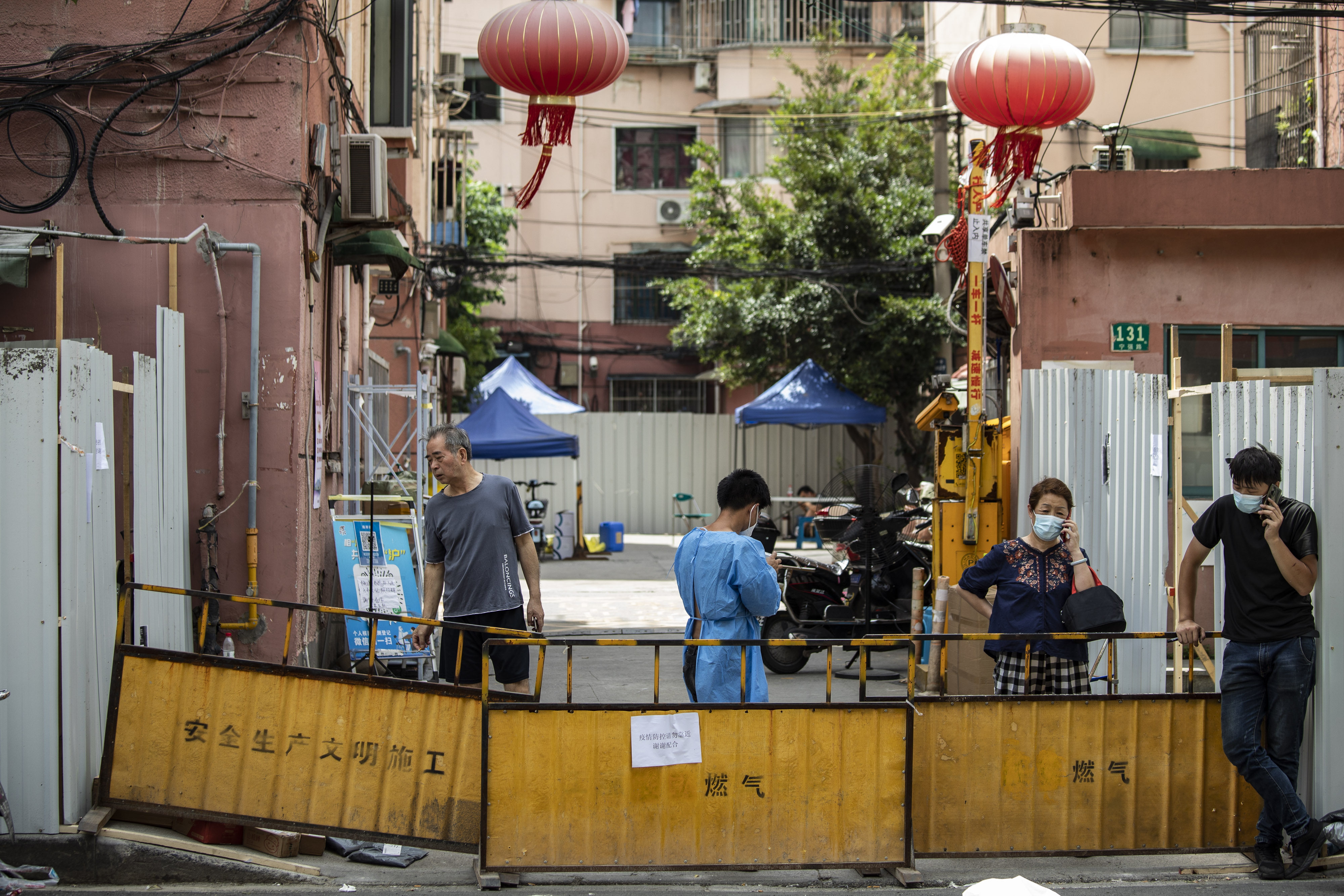 Residents behind barriers surrounding a residential neighborhood placed under lockdown due to Covid-19 in Shanghai on July 6, 2022. Shanghai launched mass testing for Covid in nine districts after detecting cases the past two days. Photo: Bloomberg