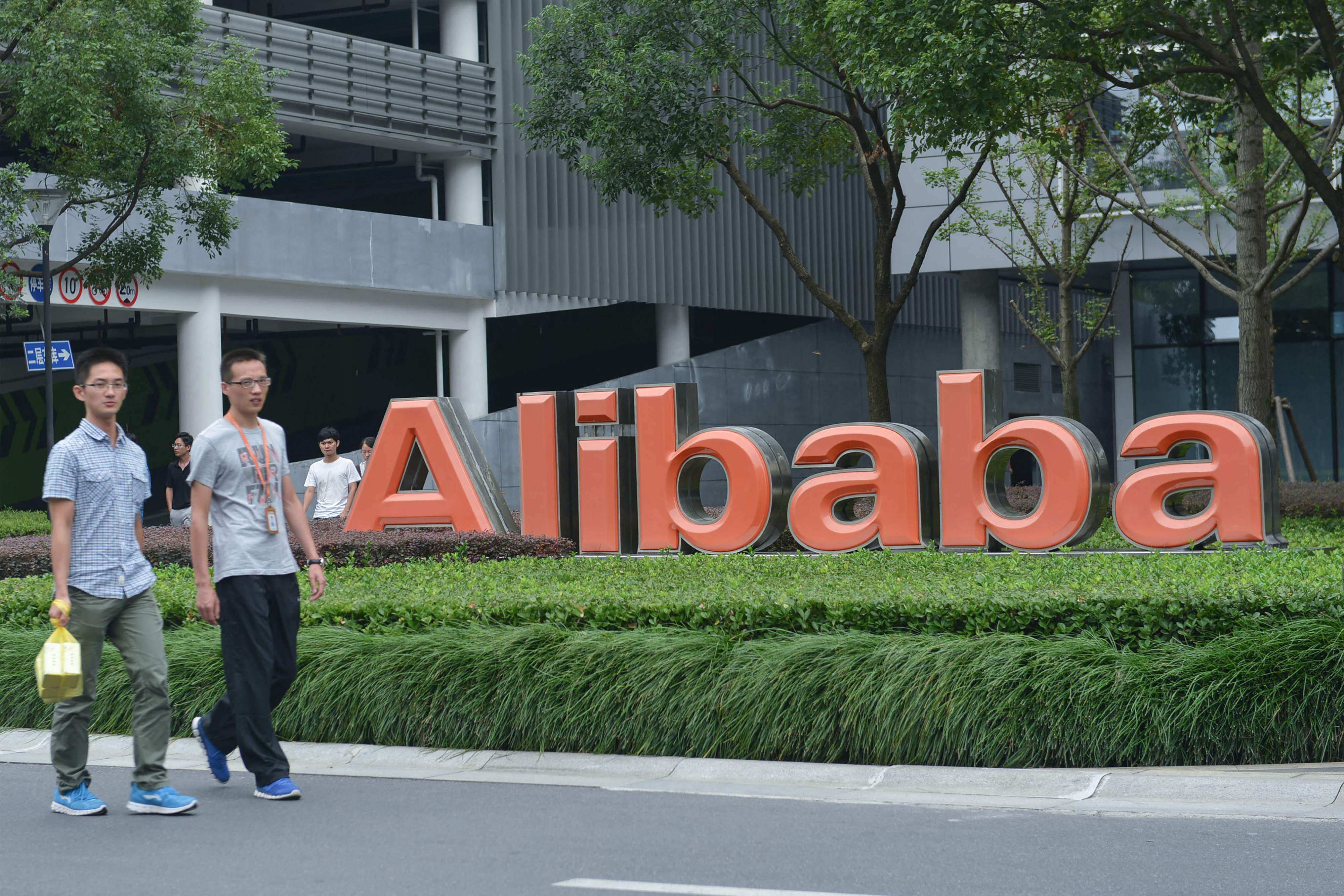 Staff members walk past a logo of Chinese e-commerce giant Alibaba at its headquarters in Hangzhou. Photo: AFP