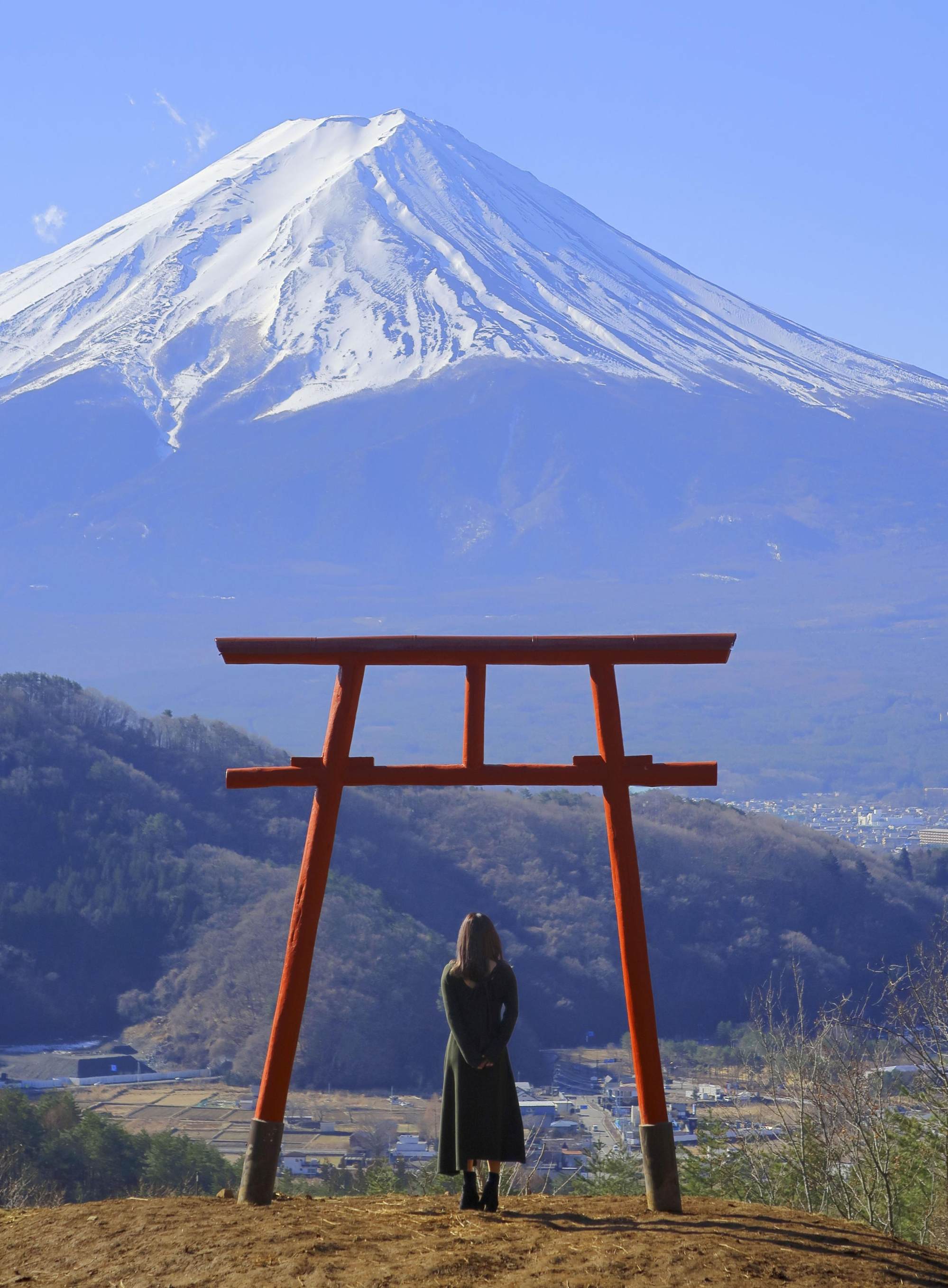 A tourist views Mt Fuji from under a torii gate in Fujikawaguchiko, Yamanashi Prefecture, Japan. Photo: Getty Images