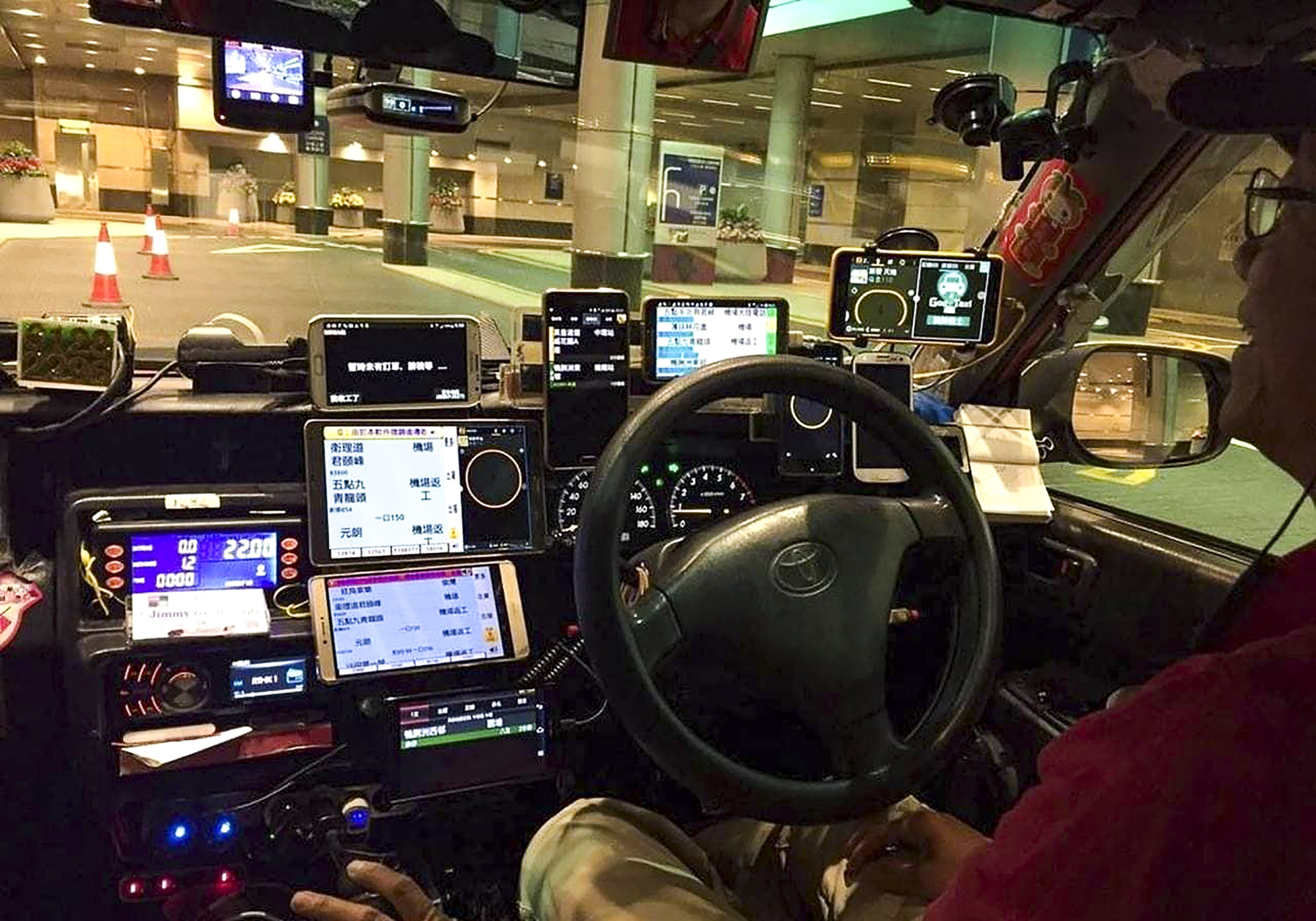 A taxi driver who has lots of phones in his taxi. Hong Kong drivers will face a maximum fine of HK$2,000 if they place more than two phones on the dashboards of their vehicles under a proposal to tighten the safety rules. Photo: Facebook