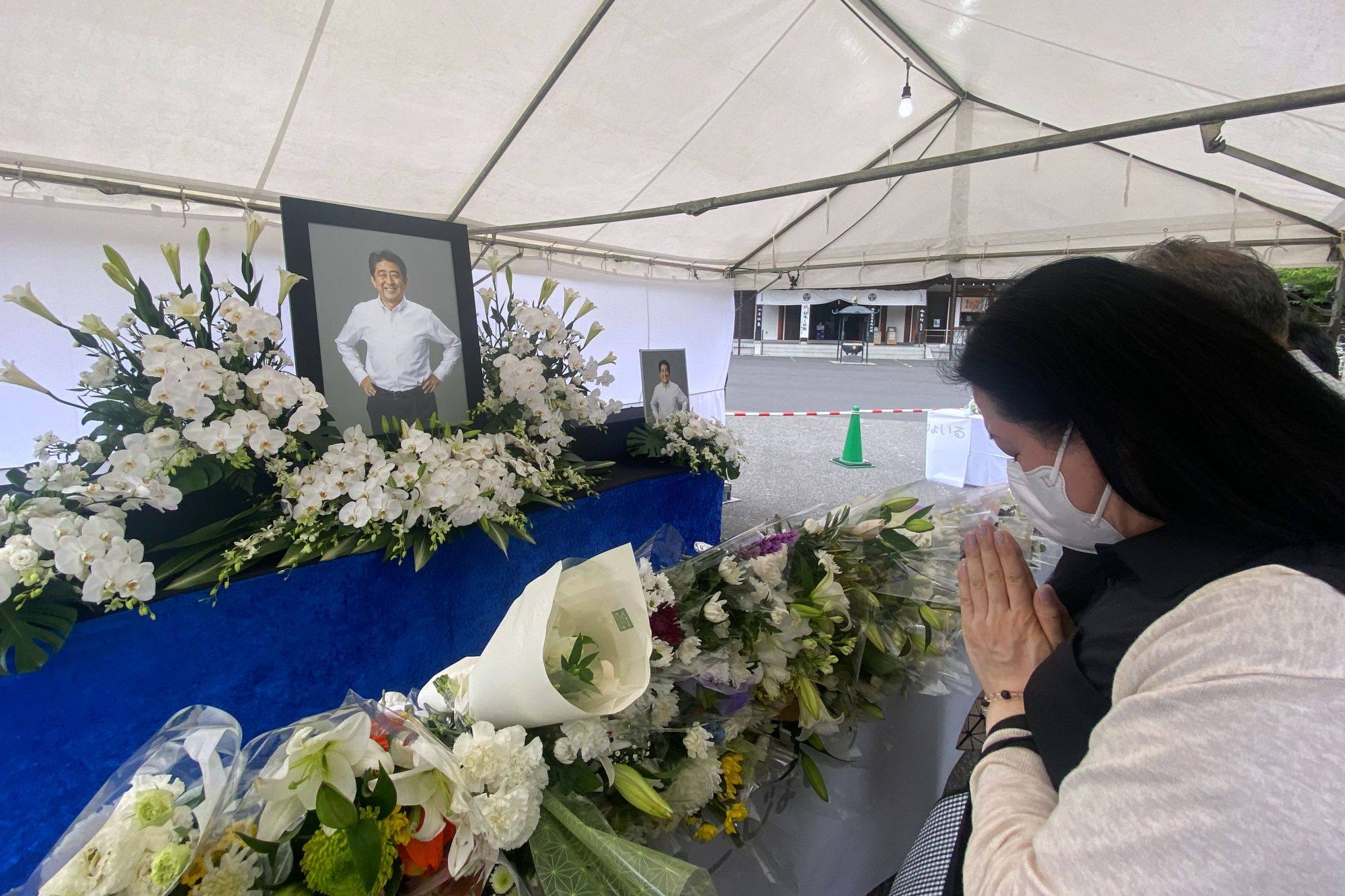 Mourners pay tribute to late former Japanese prime minister Shinzo Abe at a makeshift memorial at the Zojoji temple, in Tokyo, on July 12. Photo: Bloomberg