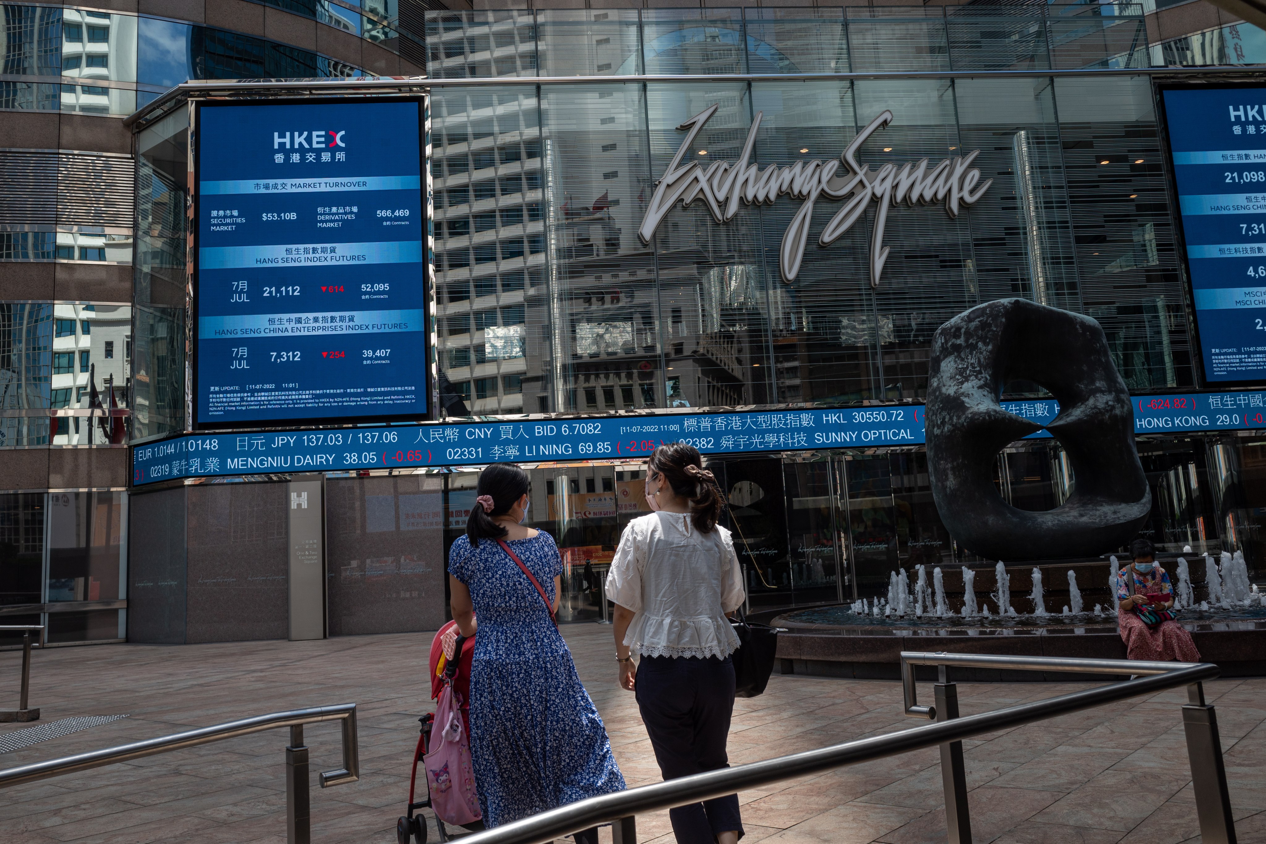 Pedestrians walk past a stock ticker outside the Exchange Square in Central, Hong Kong on July 11. Photo: EPA-EFE