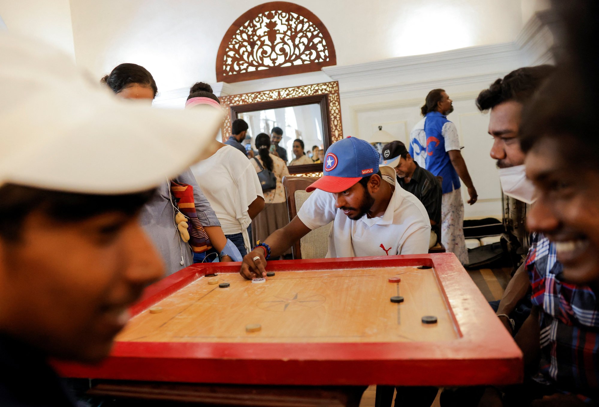 Sri Lankans play carrom inside the prime minister’s official residence in Colombo, which was stormed by protesters over the weekend. Photo: Reuters
