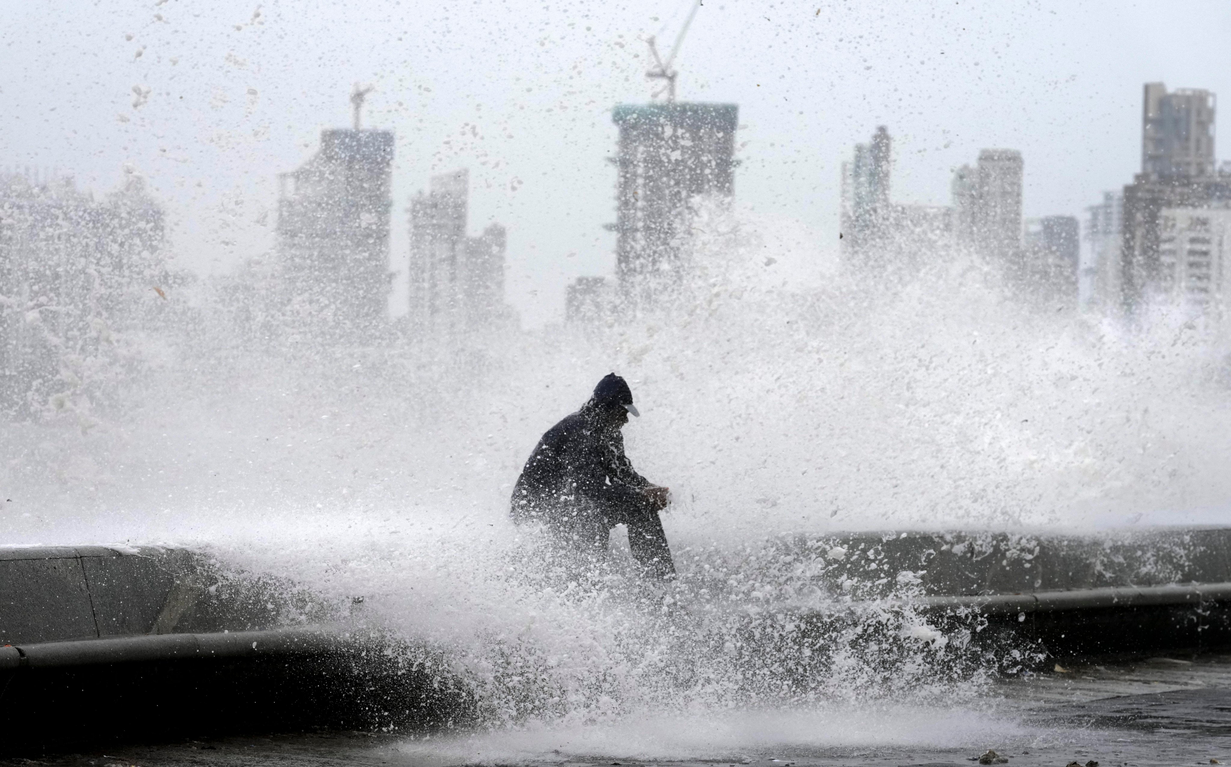 A man enjoys high tide waves during monsoon rains in Mumbai, India. Photo: AP