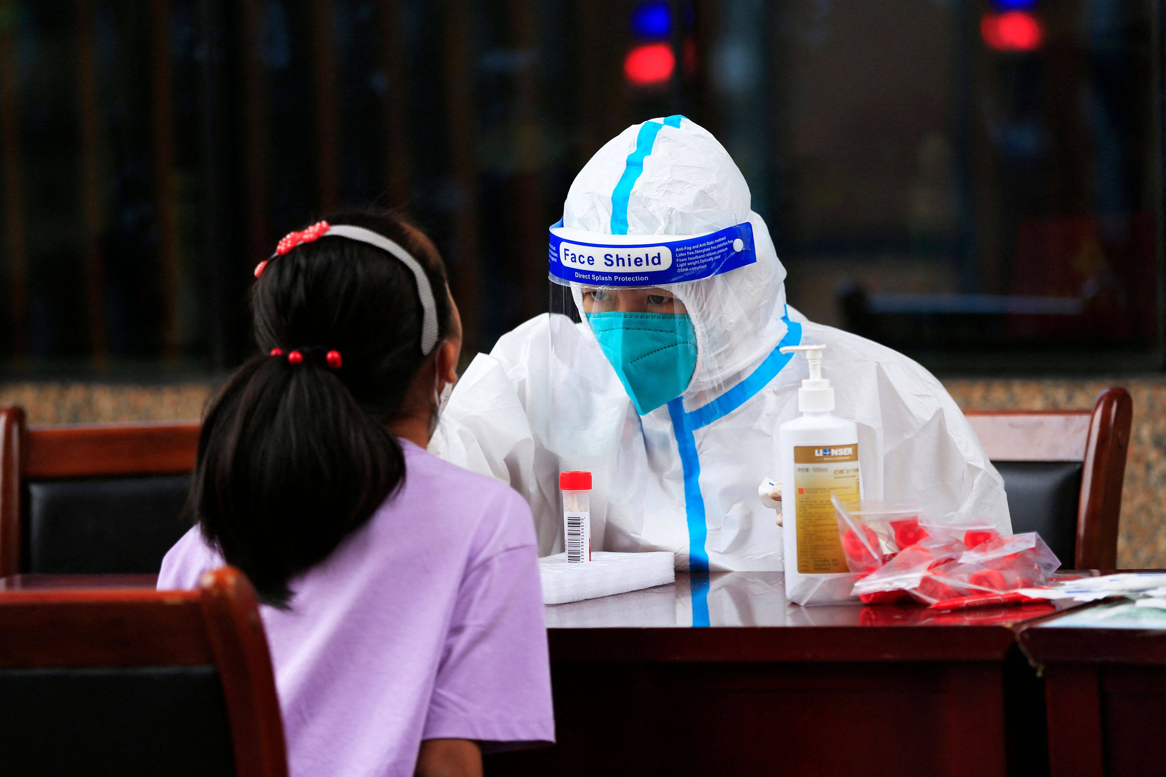 A health worker in China takes a swab sample from a child to be tested for Covid-19 as a new wave hits Asia. Photo: AFP