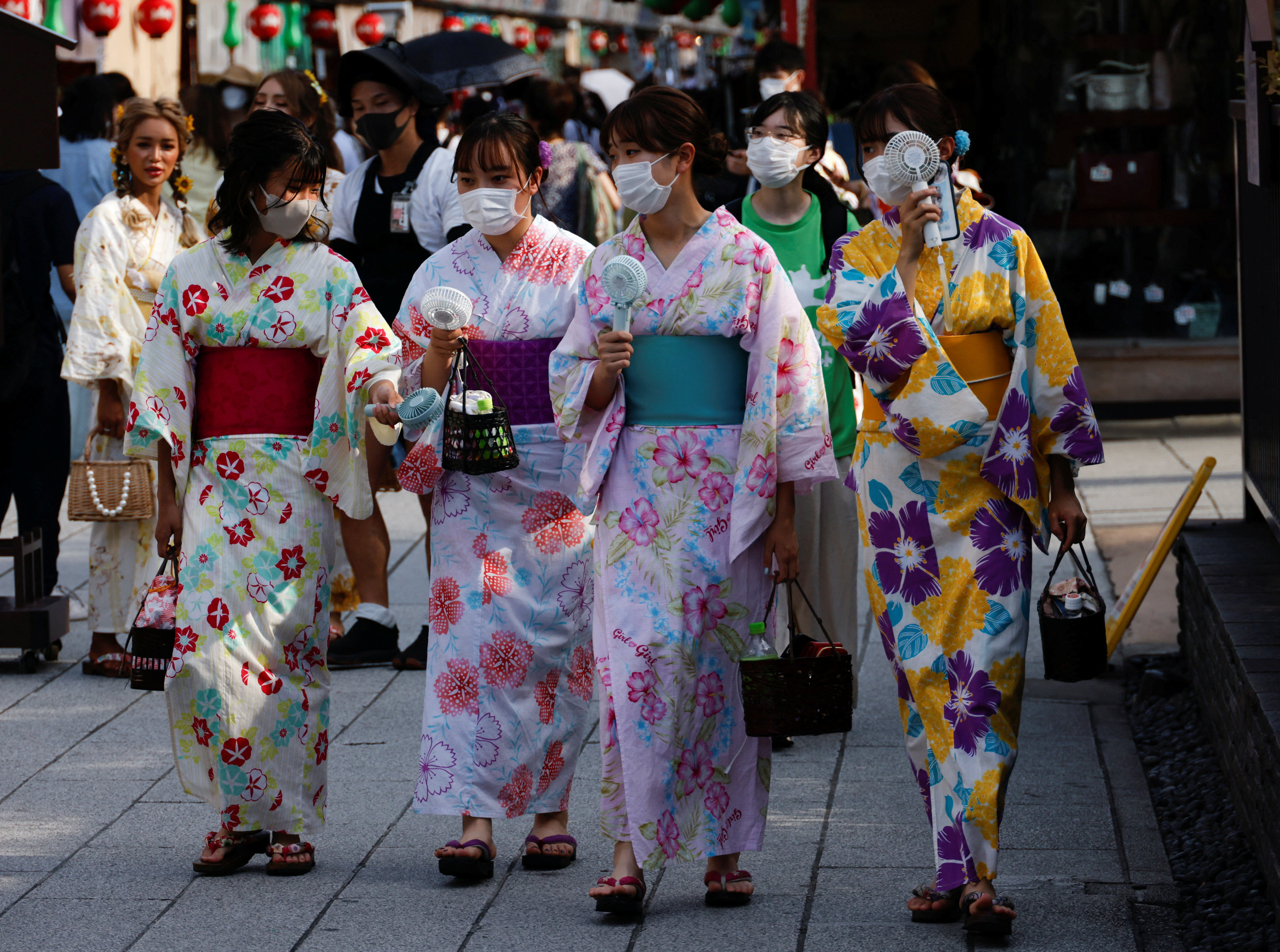 Women wearing summer kimonos use portable fans as they walk in the Asakusa district of Tokyo on June 29. Japan’s investigation of the weight and dietary habits of young women is tainted by its framing as a matter of ensuring healthy babies. Photo: Reuters