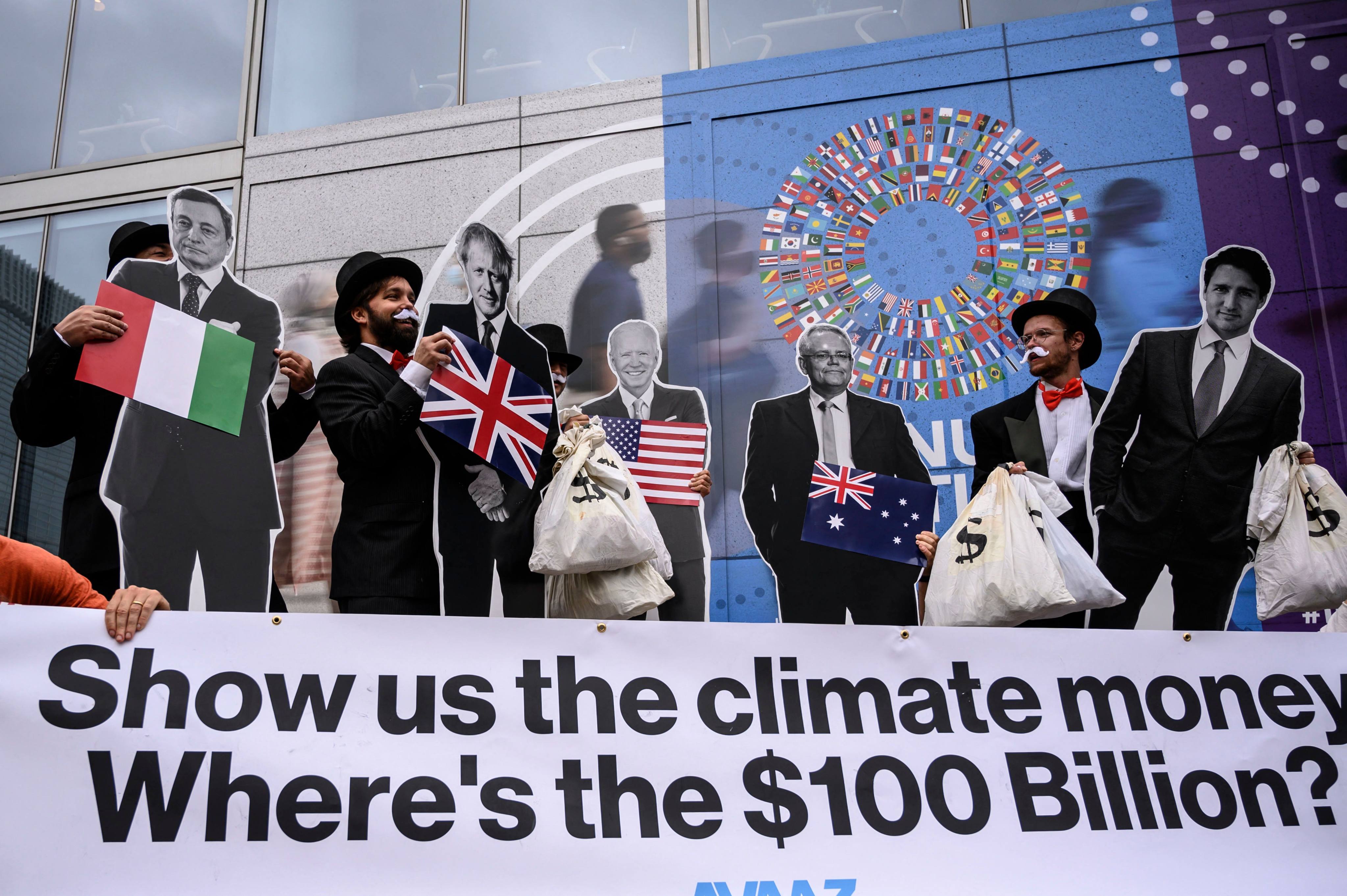 Activists dressed as “debt collectors” hold cutouts of world leaders during a demonstration in Washington, US, on October 13, 2021. Photo: AFP

