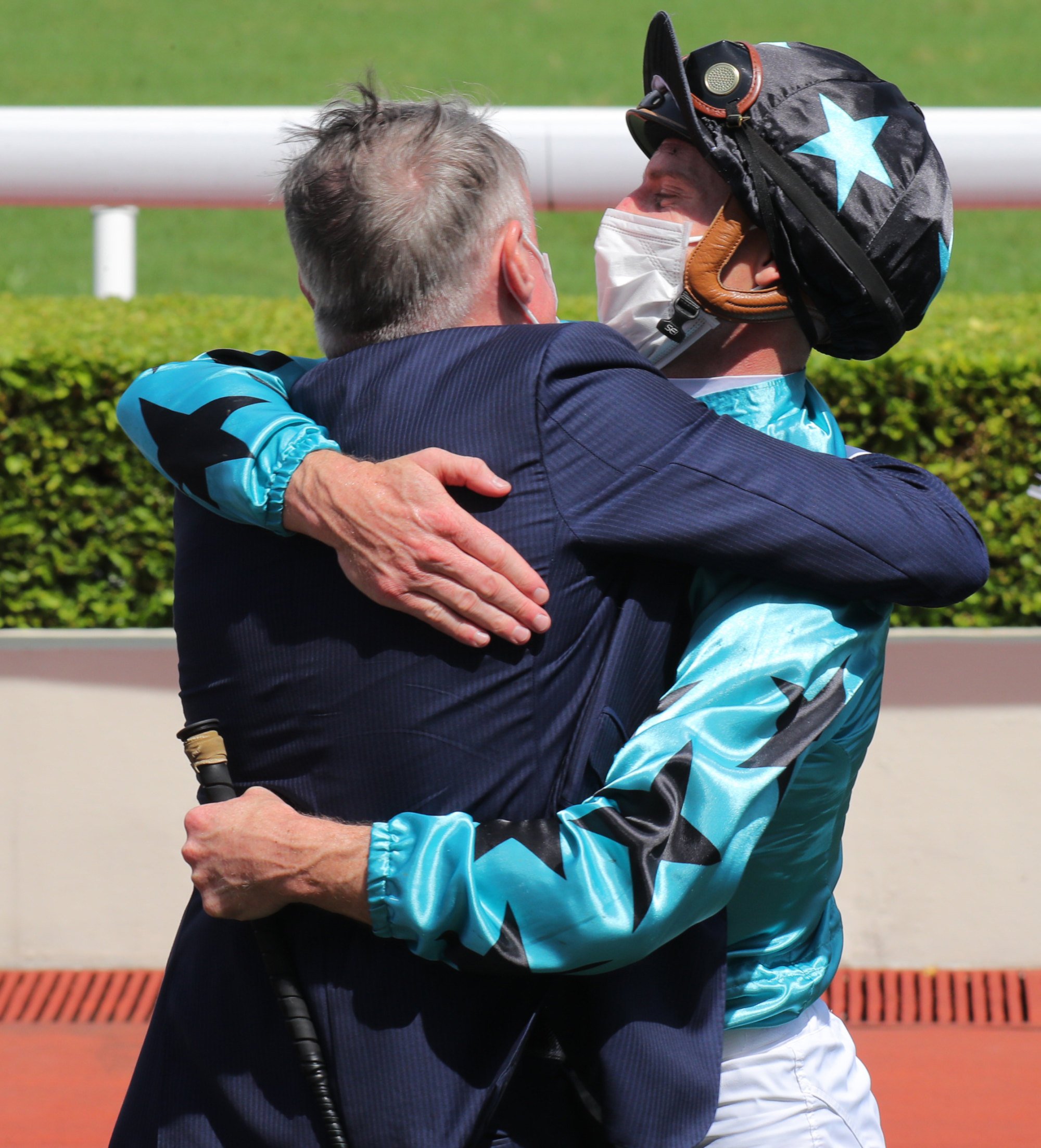 Paul O'Sullivan and Zac Purton hug after Turquoise Alpha's win.